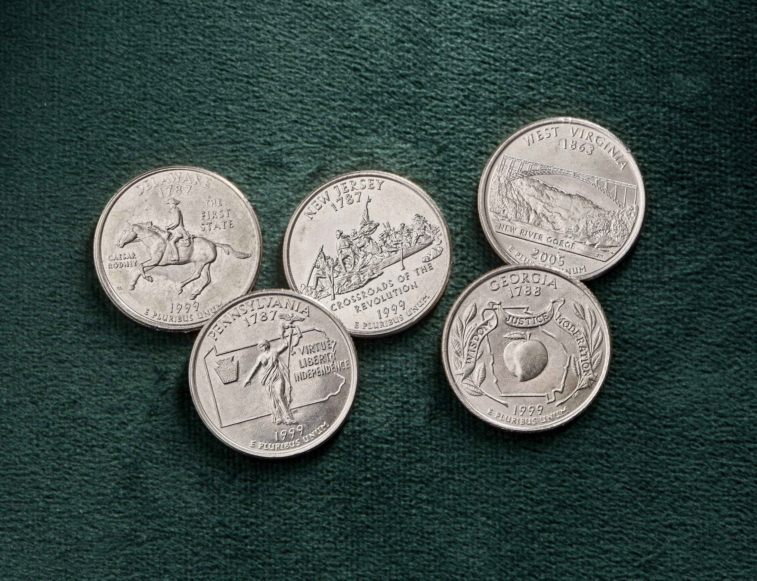 Collection of U.S. commemorative and state quarter designs, representing John Mercanti's contributions to American coinage and the artistic evolution of the America the Beautiful Quarters program.