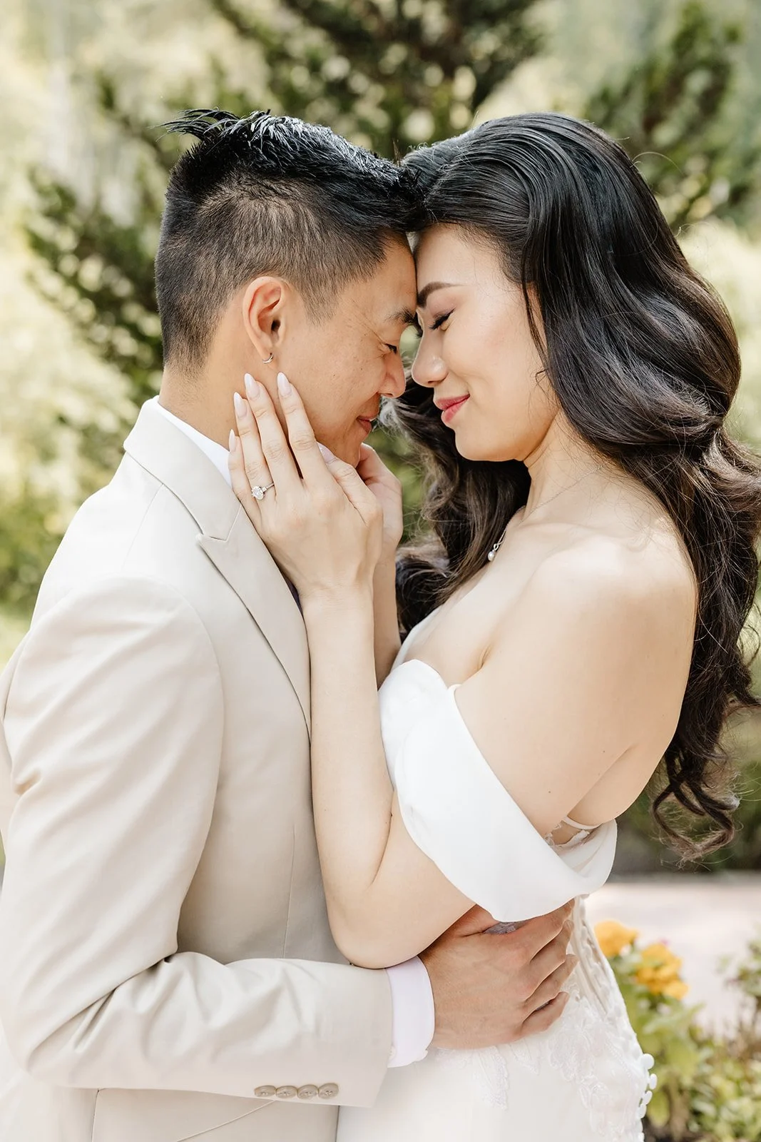 A couple dressed in wedding attire embracing outdoors, with their foreheads touching and eyes closed, surrounded by greenery.
Makeup and hair Stace Cho
Photographer Taylor Ochoa, Tminspired
Venue Jardín del sol