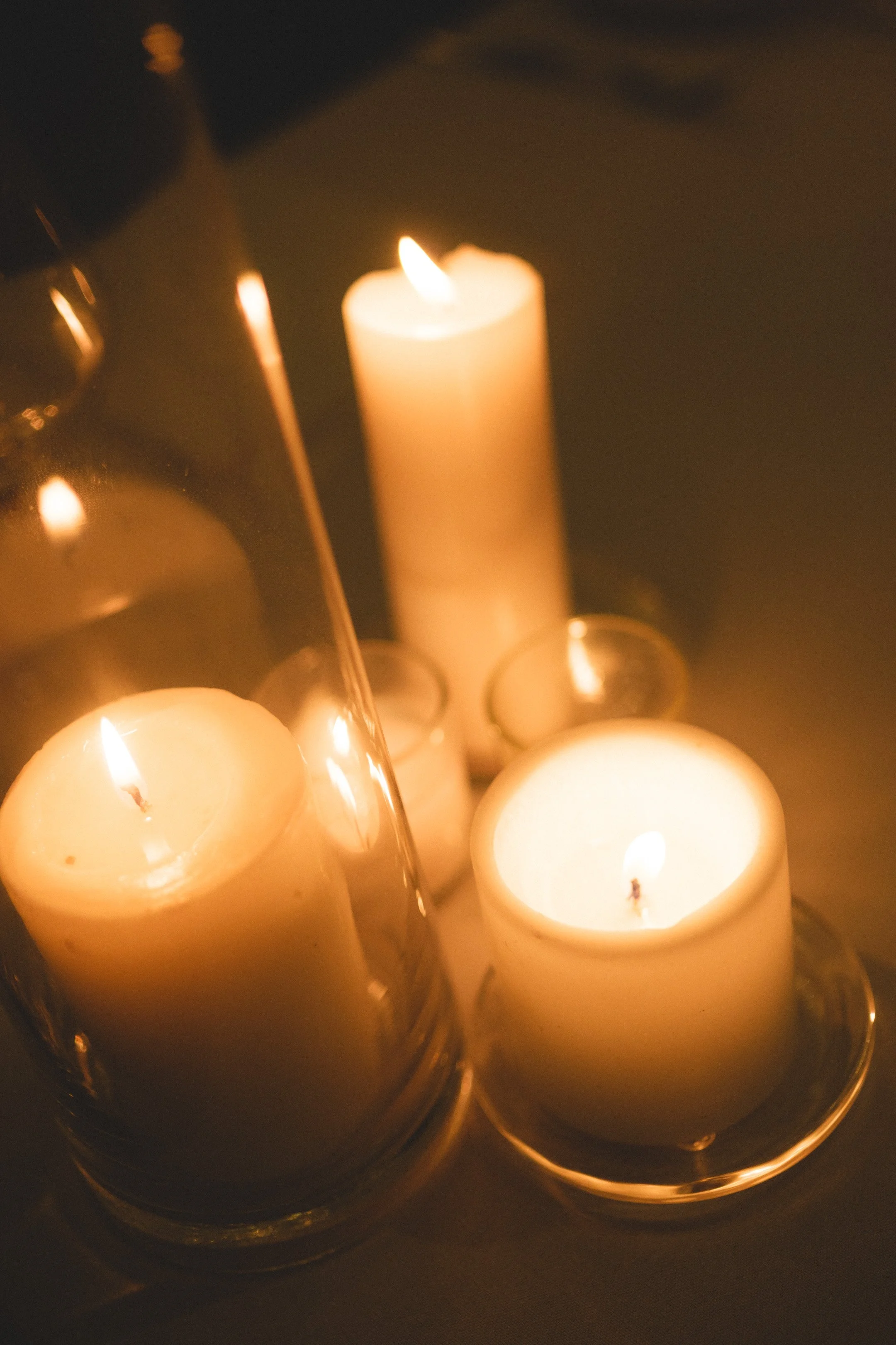 Several lit candles in glass holders creating a warm, glowing ambiance.