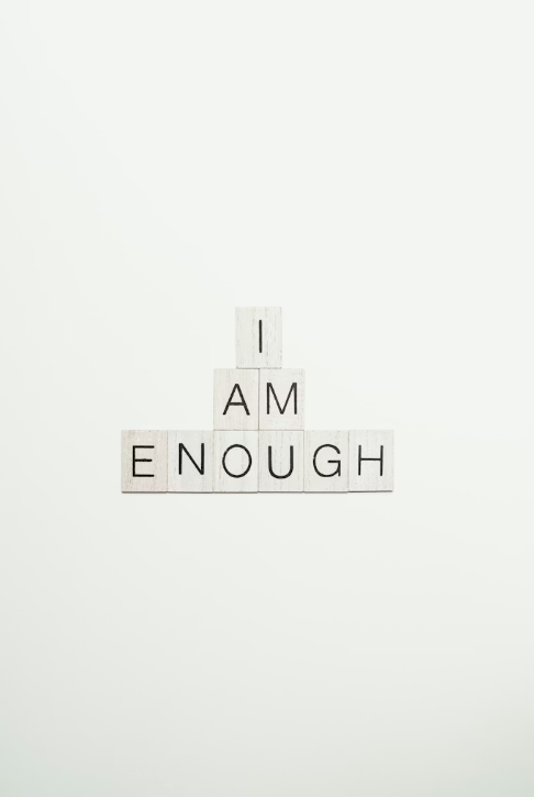Letter blocks spelling 'I AM ENOUGH' on a white background.