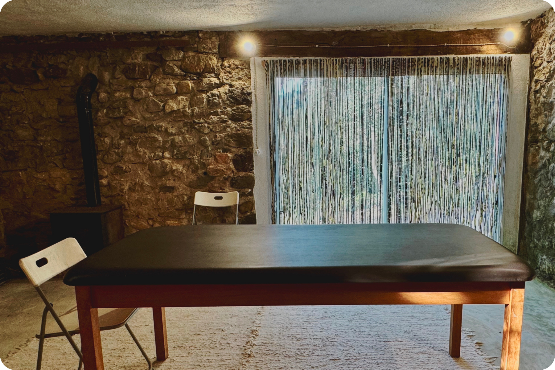 room with massage table and two chairs for bodywork