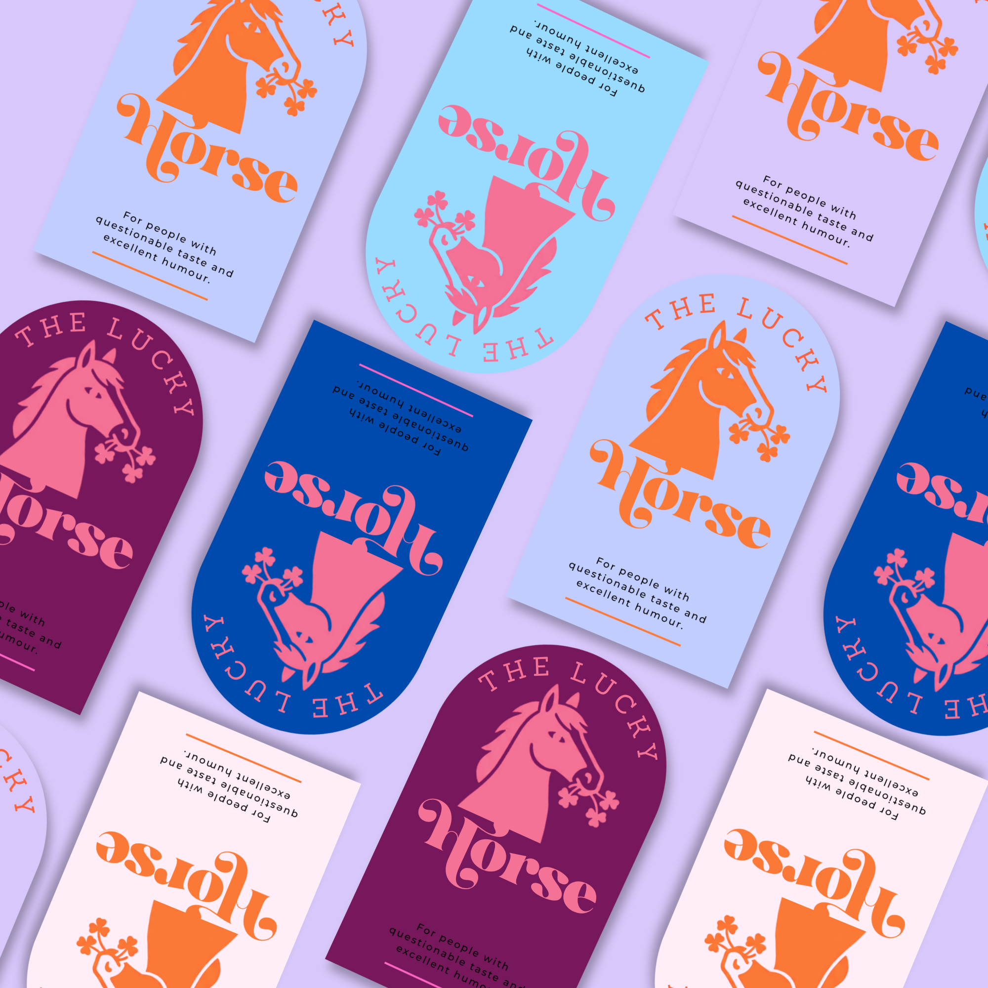 Colorful business cards with logo of a horse holding a branch with four flowers in its mouth, and the text 'THE LUCKY HORSE'. The cards have various background colors, including light blue, purple, and dark blue, with the text in contrasting orange, pink, and black. Additional text states: 'For people with questionable taste and excellent humour.'