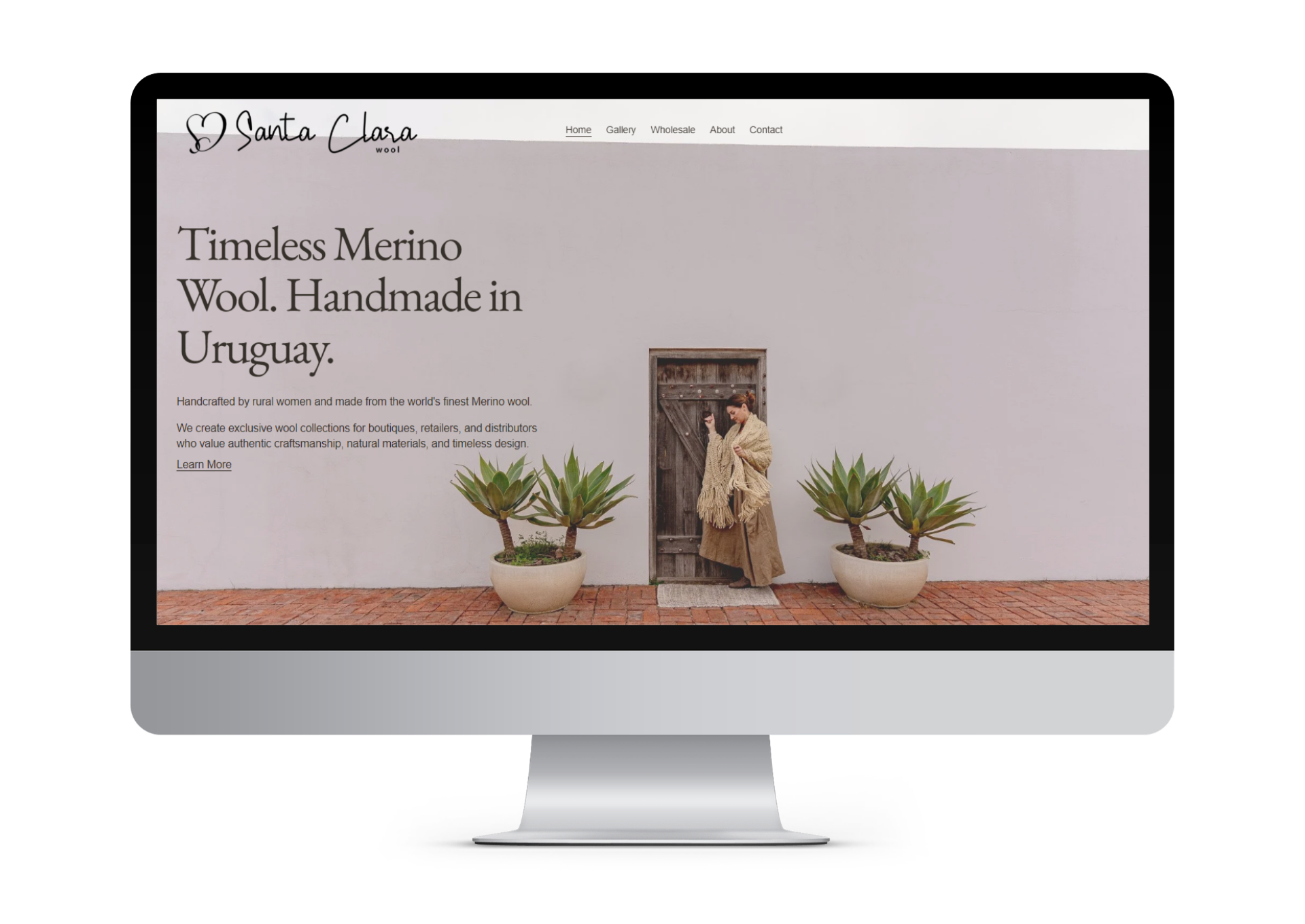 Screenshot of Santa Clara Wool website homepage showing text about Merino wool, a woman in a coat and scarf standing near a wooden door, flanked by large potted plants on a brick sidewalk.