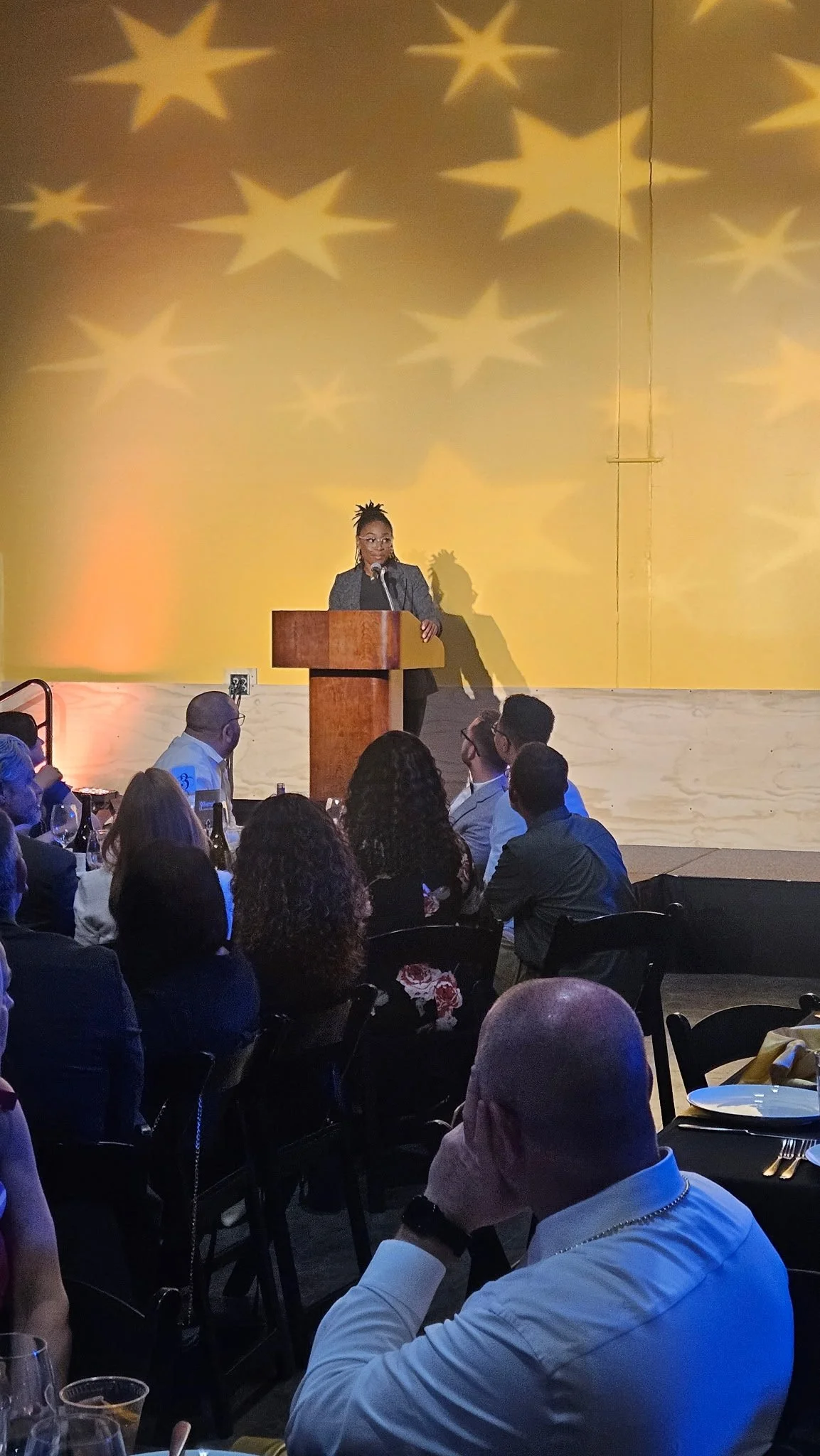 Rashida Saunders delivering a keynote presentation to an audience at a formal event.