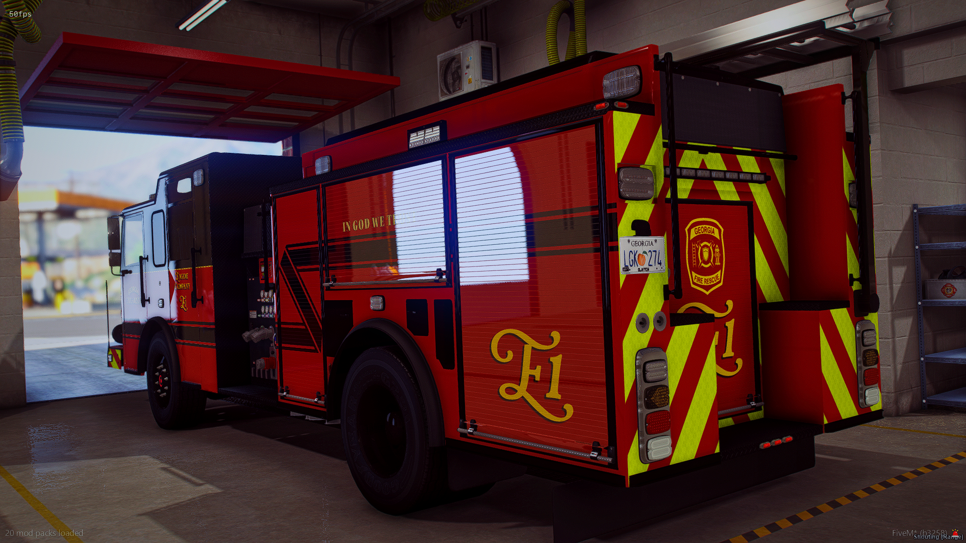 Red fire rescue truck parked inside a fire station garage with yellow and black safety markings on the floor.