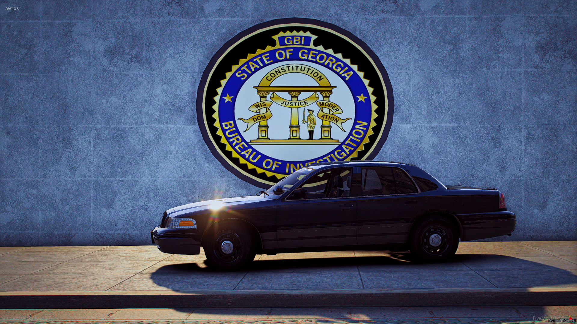 A black police car parked in front of a wall with the Georgia Bureau of Investigation insignia.