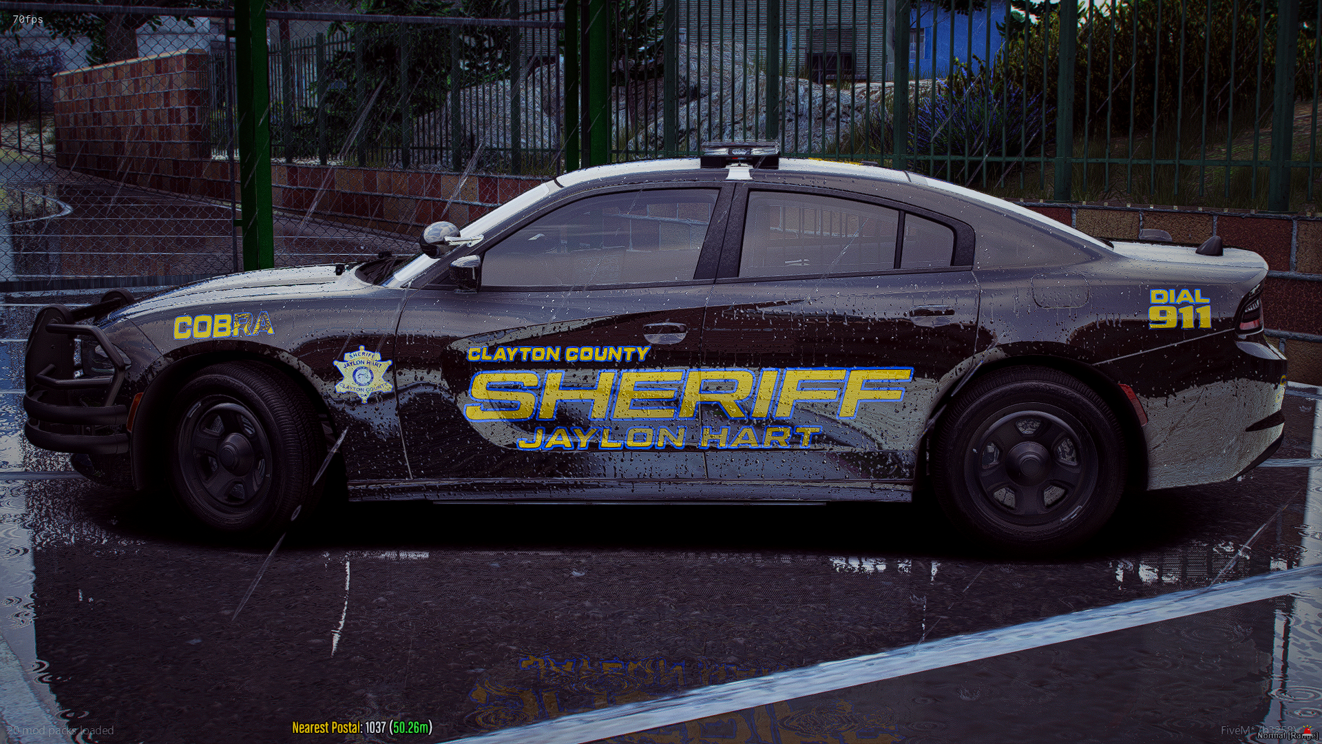 Black Clayton County Sheriff's patrol car covered in soap and water, parked on wet pavement, with fences and greenery in the background.