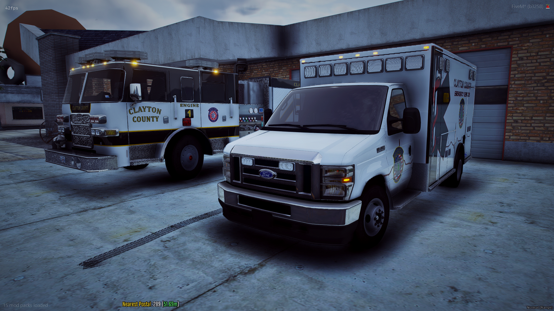 Fire truck and emergency medical services vehicle parked outside building.