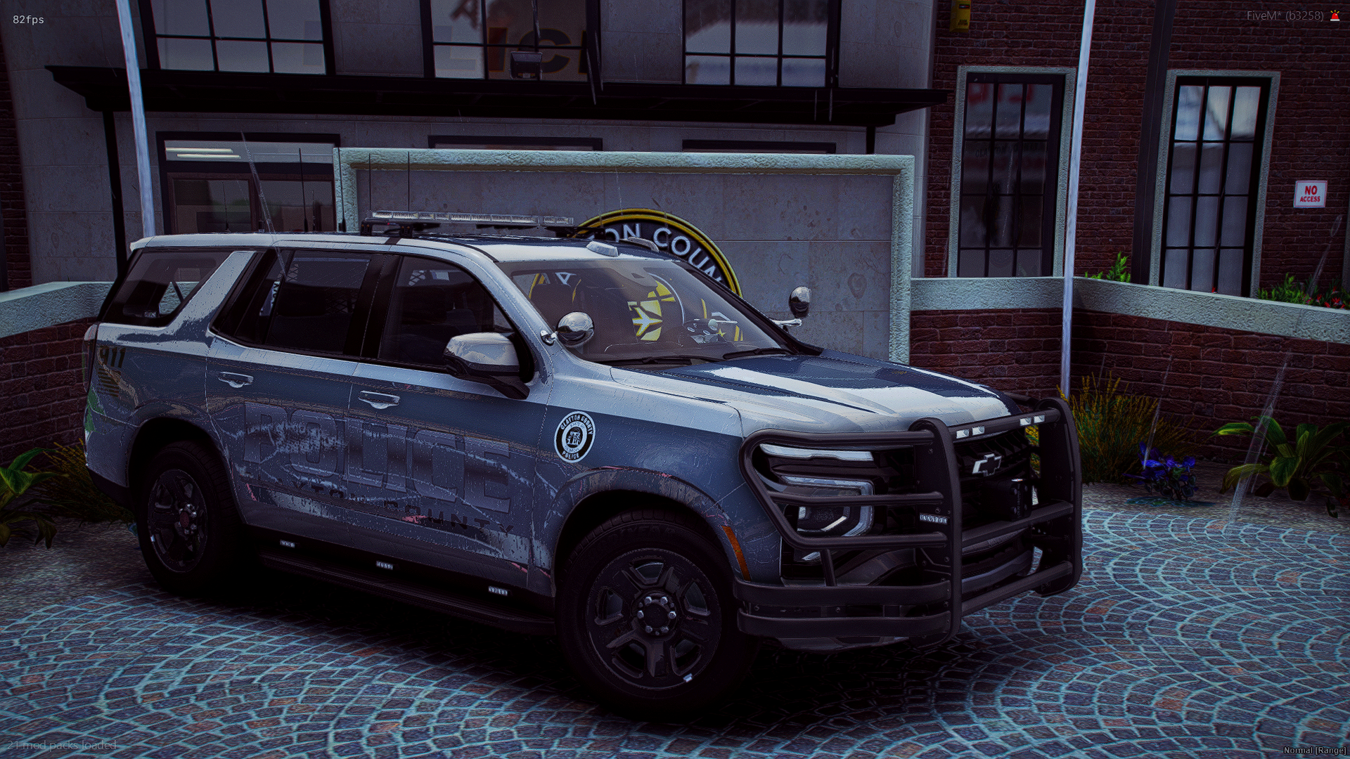 A police vehicle parked outside a building, with a sign that reads 'No Access' on the wall nearby.