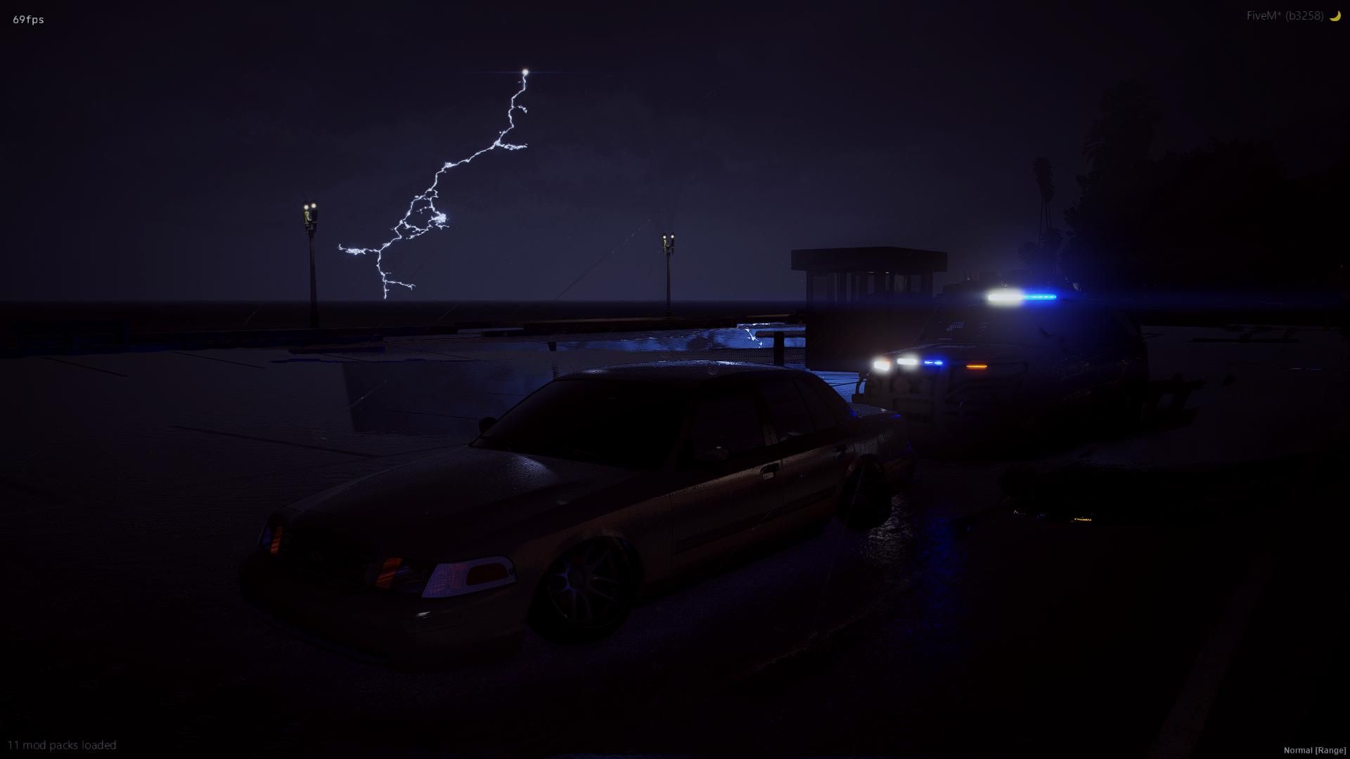Nighttime scene with a lightning strike in the sky, a police car with flashing lights, and a parked sedan on a wet surface near coastal area with palm trees and a small building.