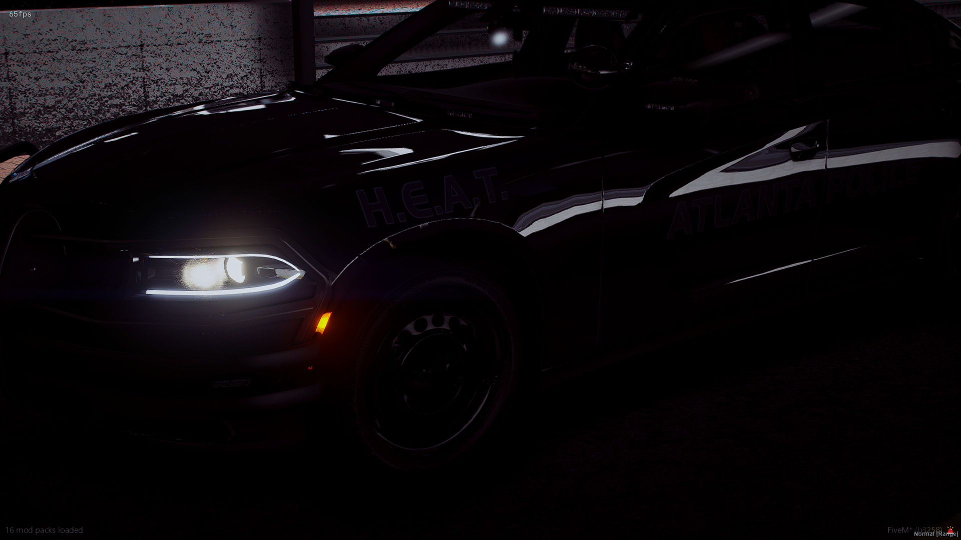 A black police car with flashing lights parked in a garage or parking area, with visible text indicating it belongs to Atlanta Police and H.E.A.T.
