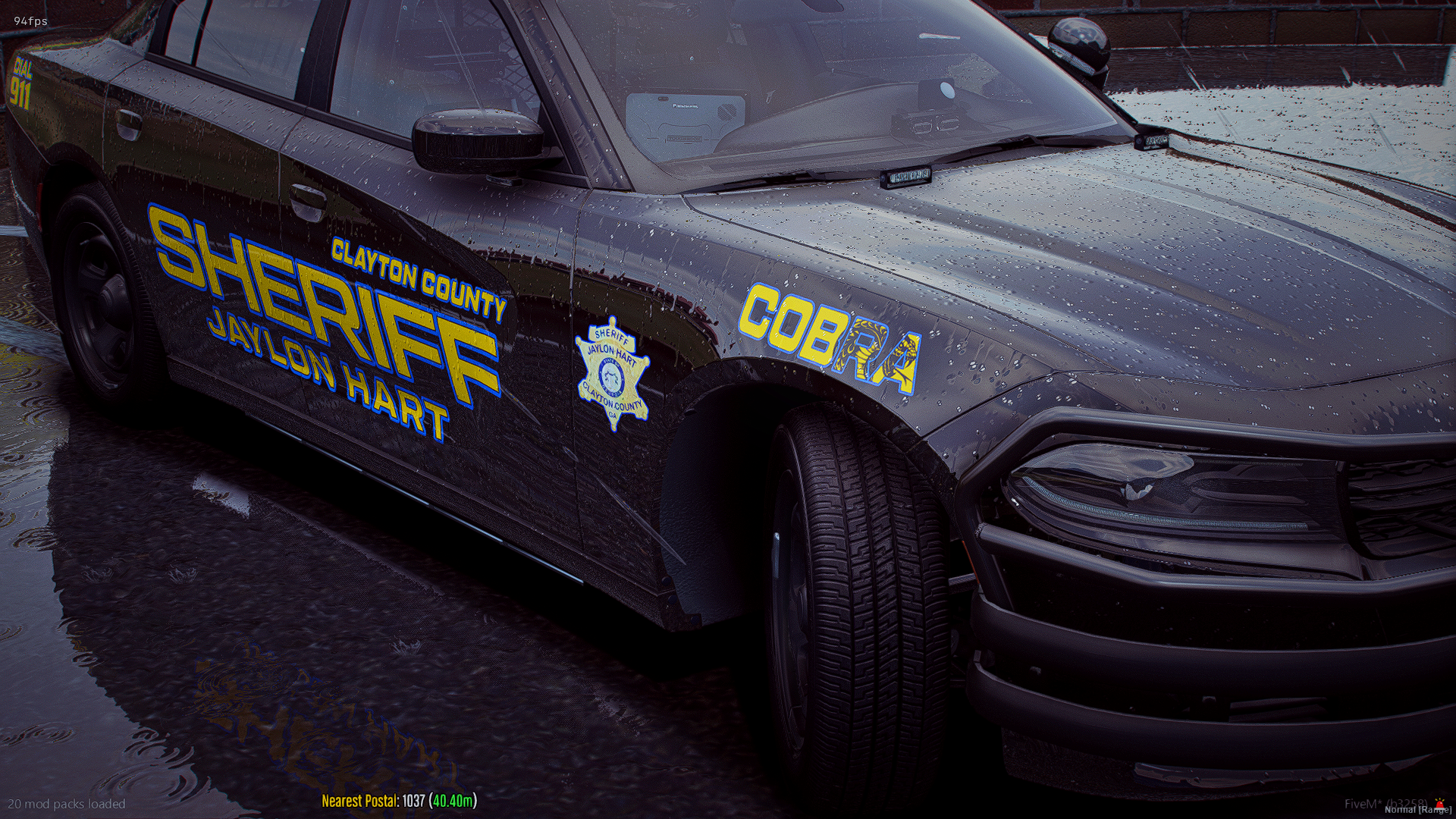 A black sheriff's patrol car from Clayton County, Jaylon Hart, parked on a wet surface with raindrops on the hood, with emergency lights and police insignia visible.