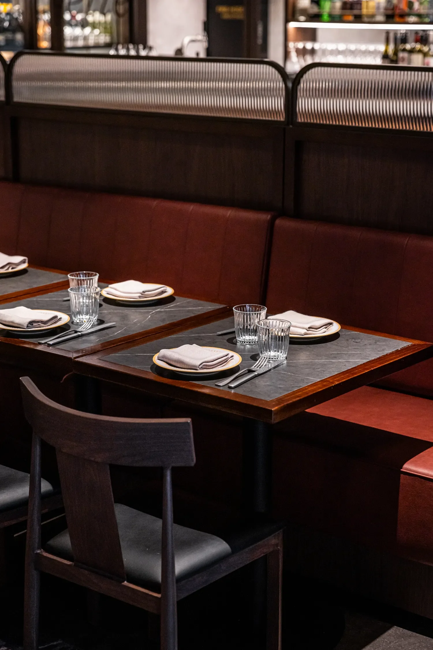 Empty restaurant table set with plates, napkins, glasses, and utensils.