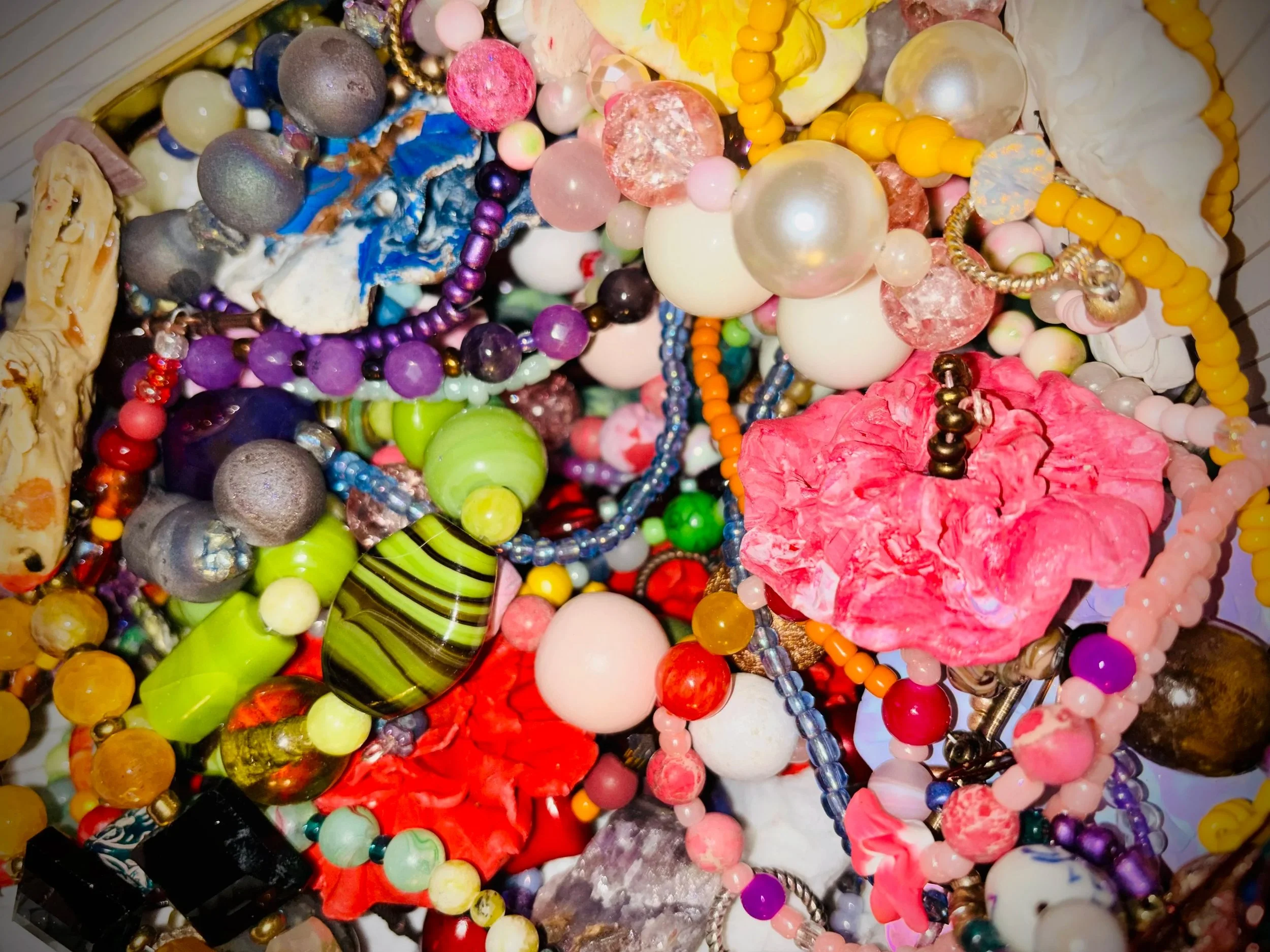An image of beads and a handmade flower pendant