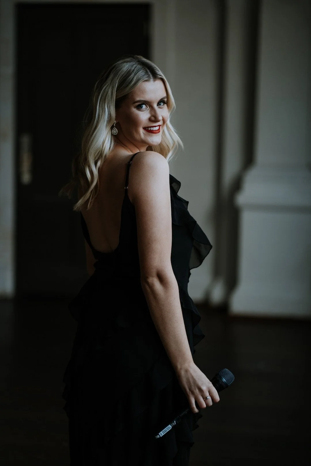 Stella Kelly singer at Moana Hall Perth holding a microphone and smiling