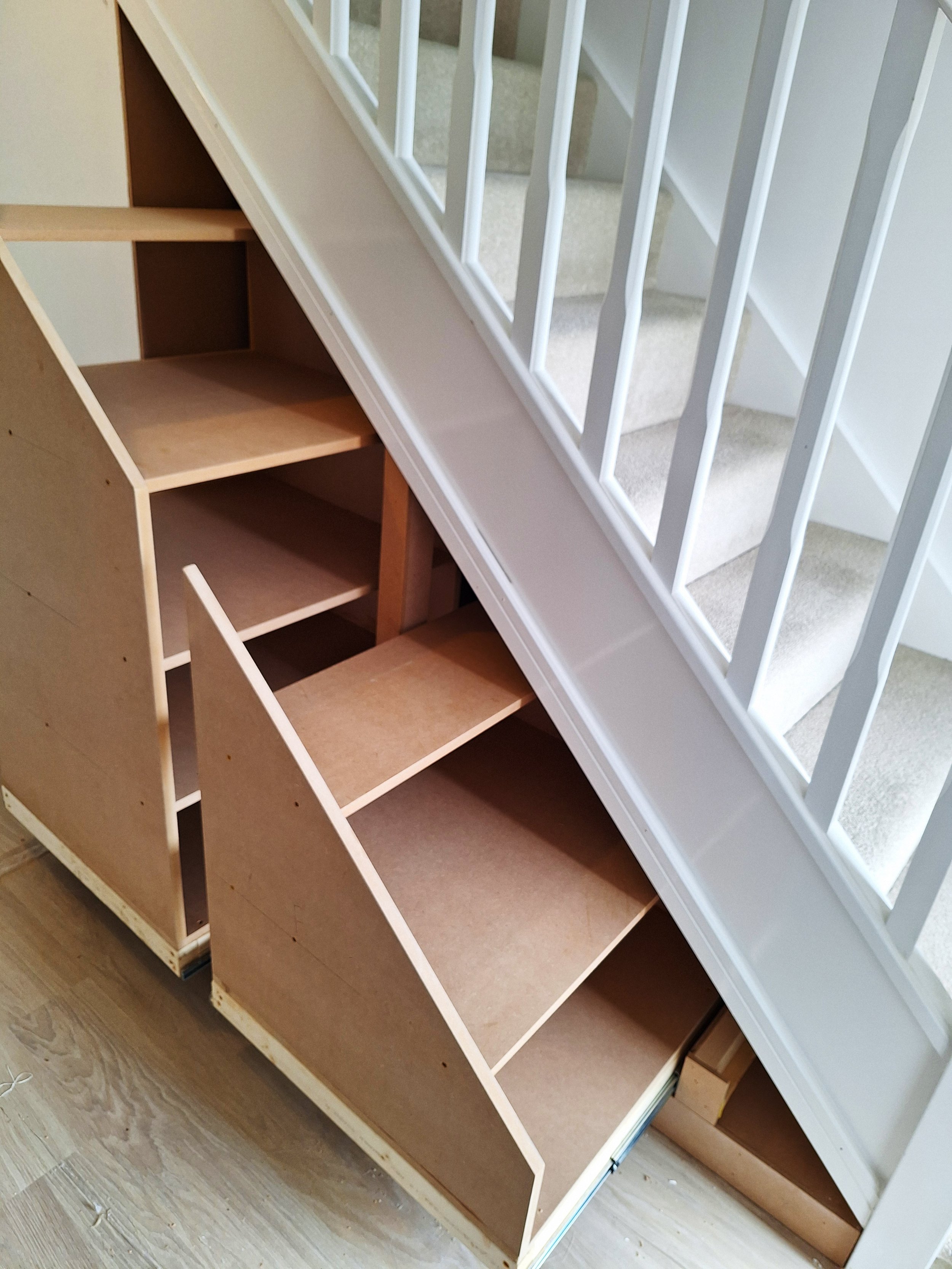 Wooden pull out shelving under stairs