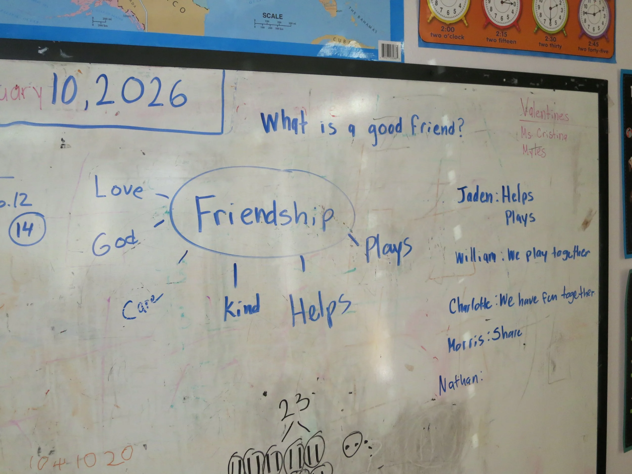 Whiteboard with handwritten notes and questions about friendship, including qualities like love, kindness, and helpfulness. The date January 10, 2026 is written at the top. There are names and comments about friends playing and having fun together. S