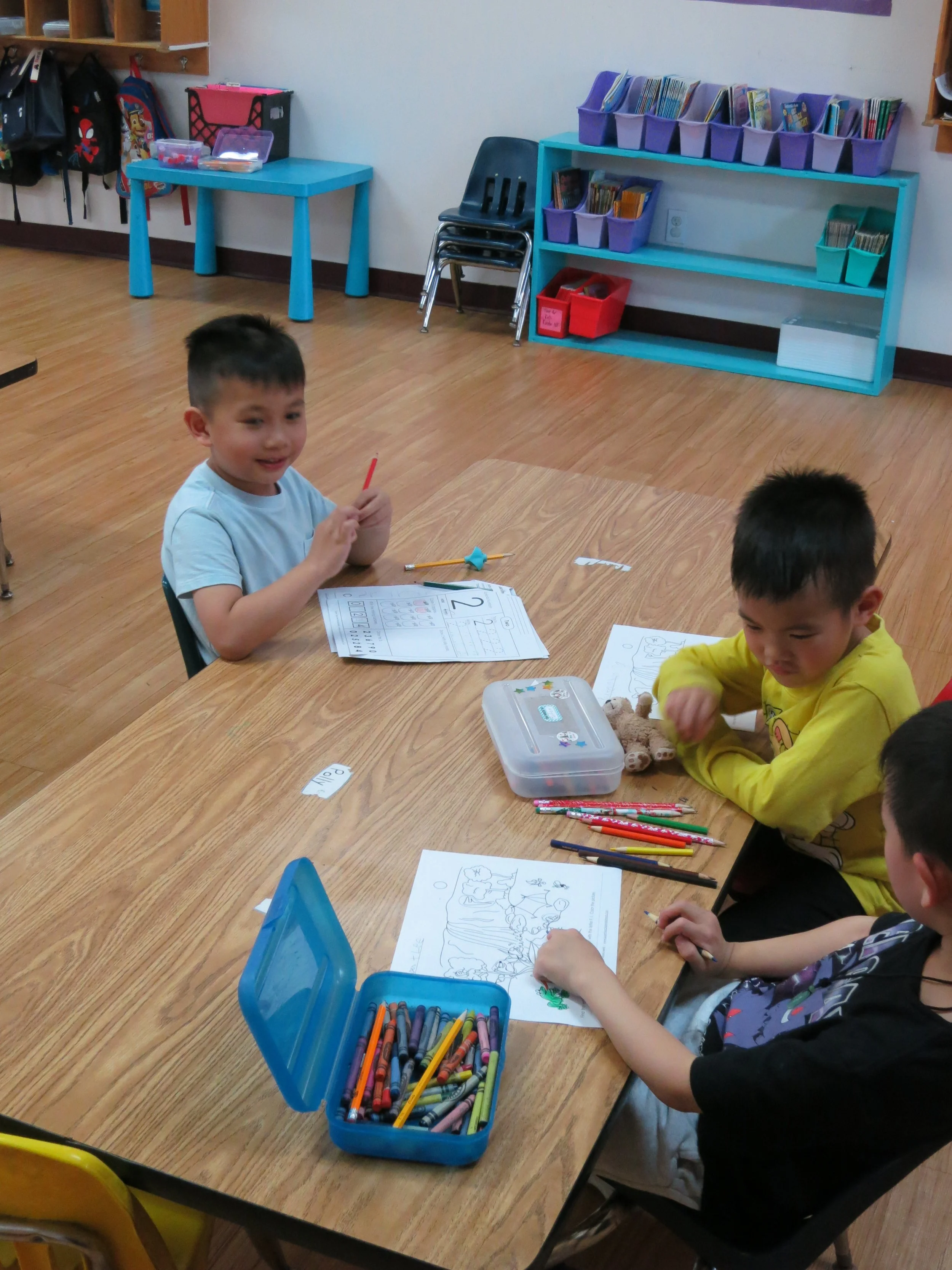 Three private school kindergarten students are working on school assignments together. (The Cross Schools of Education - Walnut, CA)