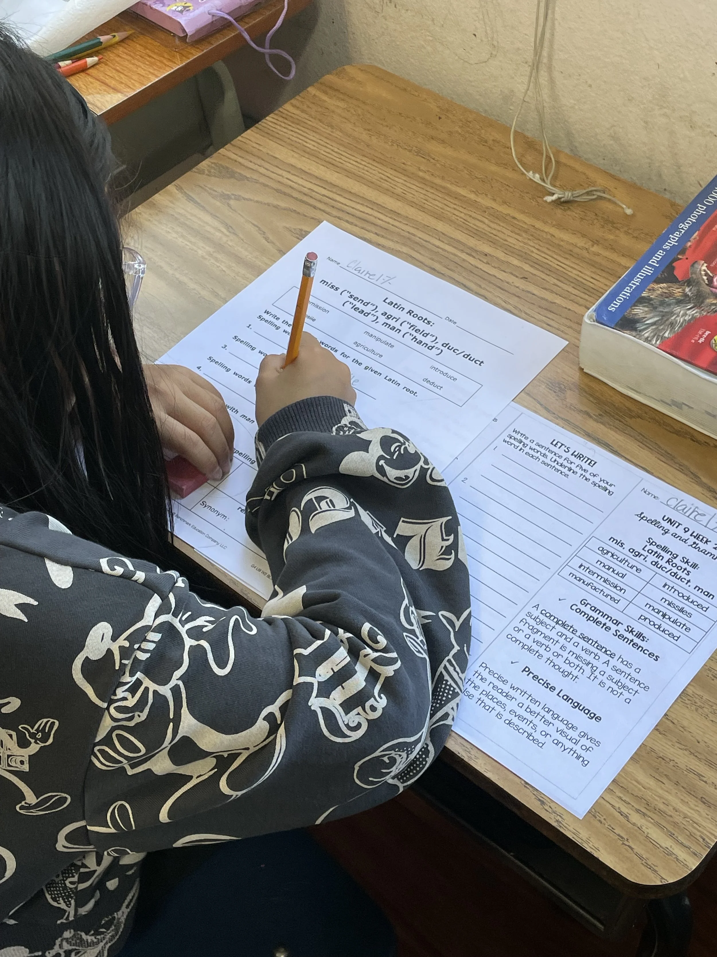 A kindergarten female student completing supplemental writing and reading worksheets at The Cross Schools of Education After-School Program in Walnut, CA.