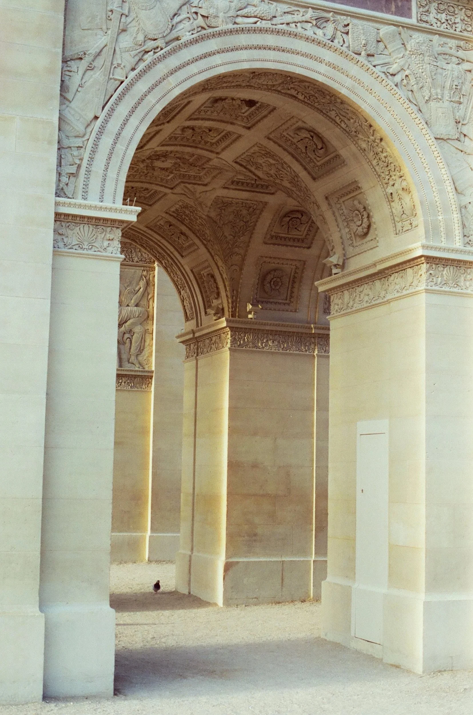 Arched structure with ornate carvings and detailed ceiling, part of a historic monument or building.
