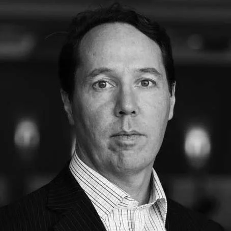 Black and white portrait of a man in a suit and collared shirt.