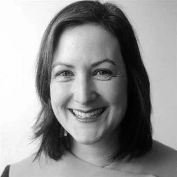 Black and white photo of a smiling woman with shoulder-length hair.
