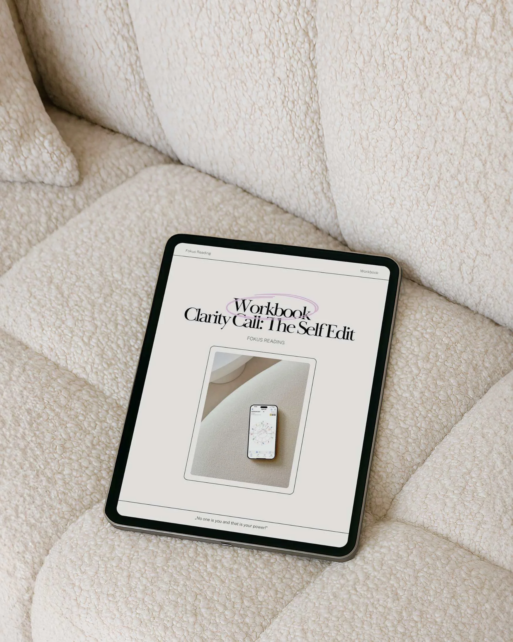 Ein Tablet liegt auf einem beigen, kuscheligen Sofa, das Bildschirm zeigt eine PDF mit dem Titel 'Workbook Clarity Call: The Self Edit' und einem Bild eines Smartphone auf einem ähnlichen Sofa.