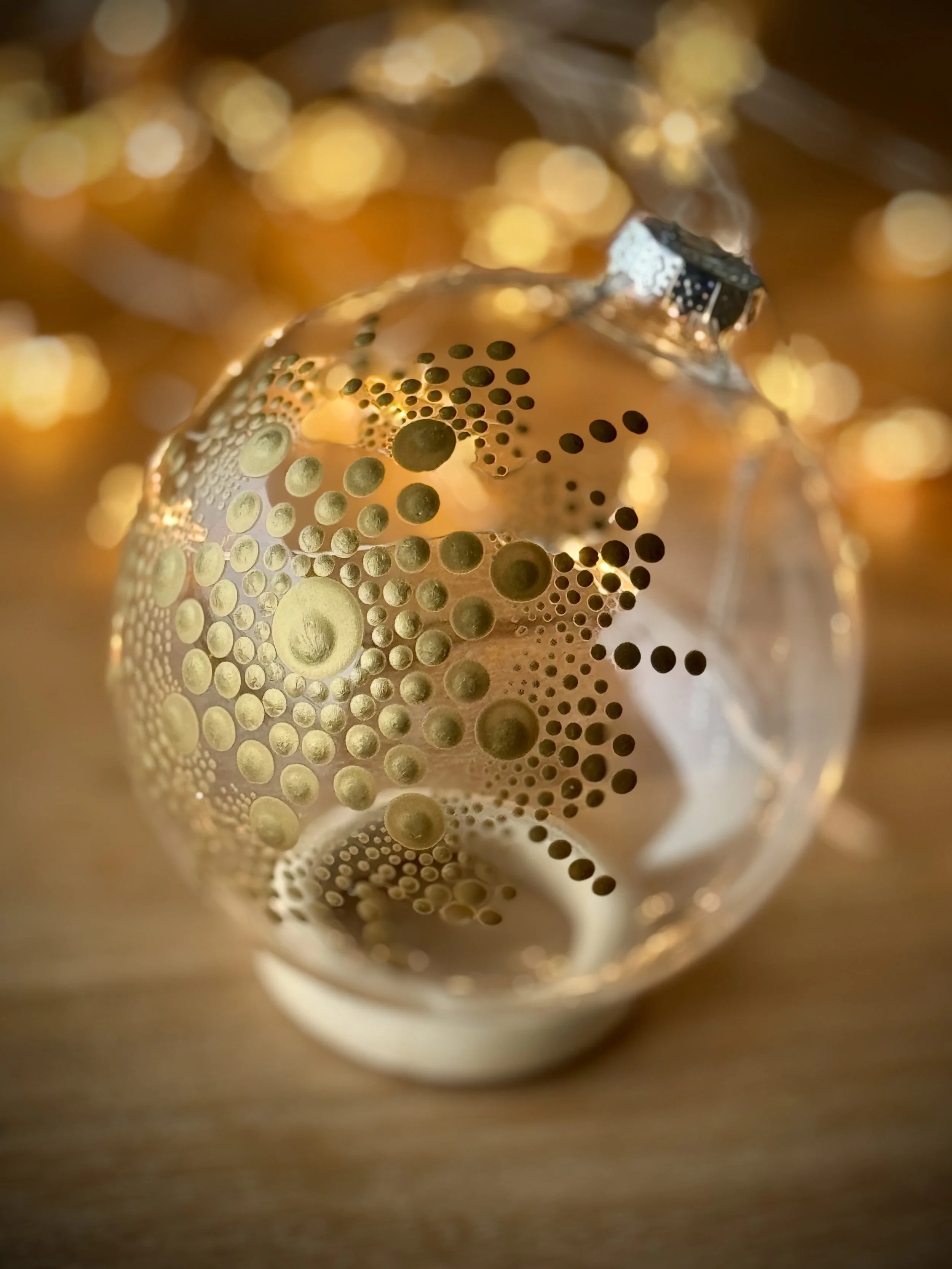 Close-up of a metallic ice bucket with a pattern of various sized circles, illuminated with warm lighting, against a blurred background.