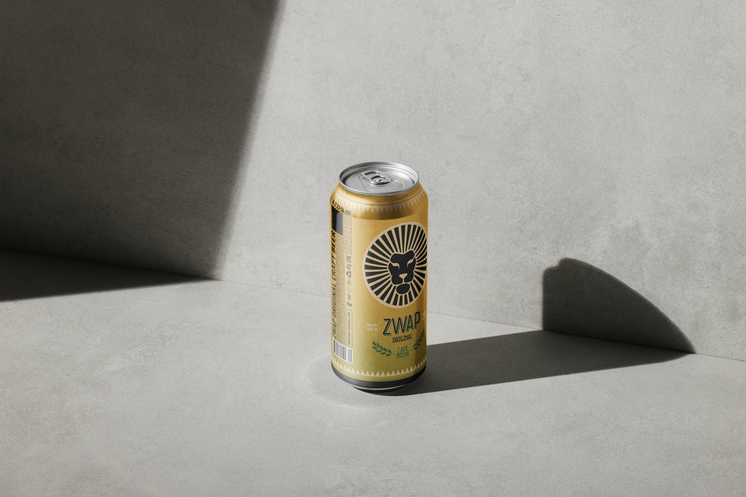 Une canette de boisson ZWAP Original au design jaune avec un lion stylisé et le texte 'CAP. BREV' et 'LION' sur l'emballage, posée sur une surface en béton sous un éclairage créant une ombre distincte.