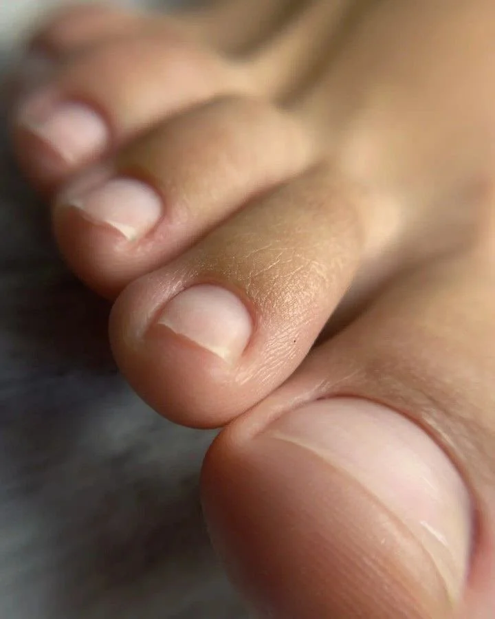 Close-up of a person's fingernails and fingertips, showing the details of the skin and nails.