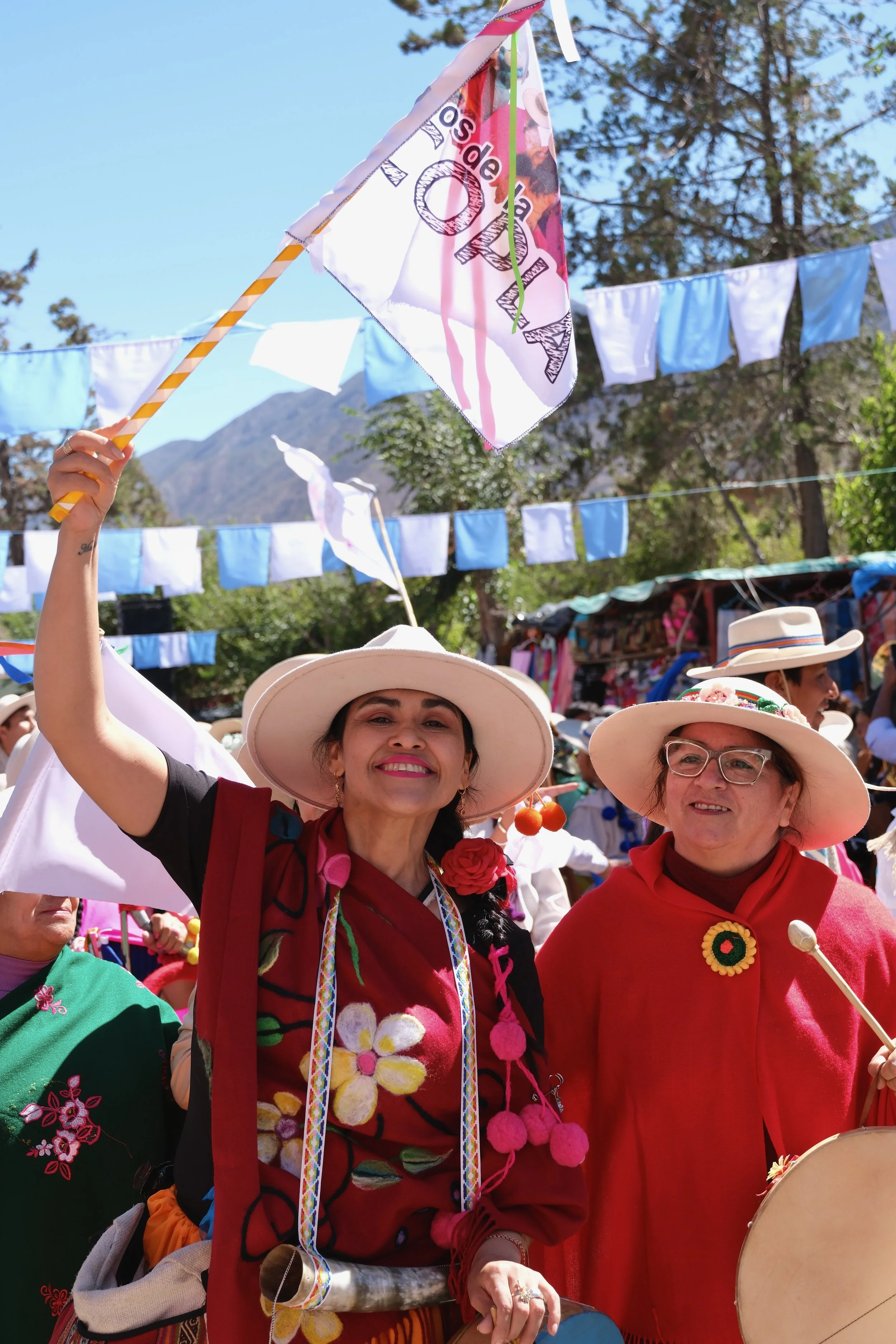 Two performers stand proudly raising a flag during the summer solstice celebration in Tilcara, Argentina, on Jan. 9, 2026.
