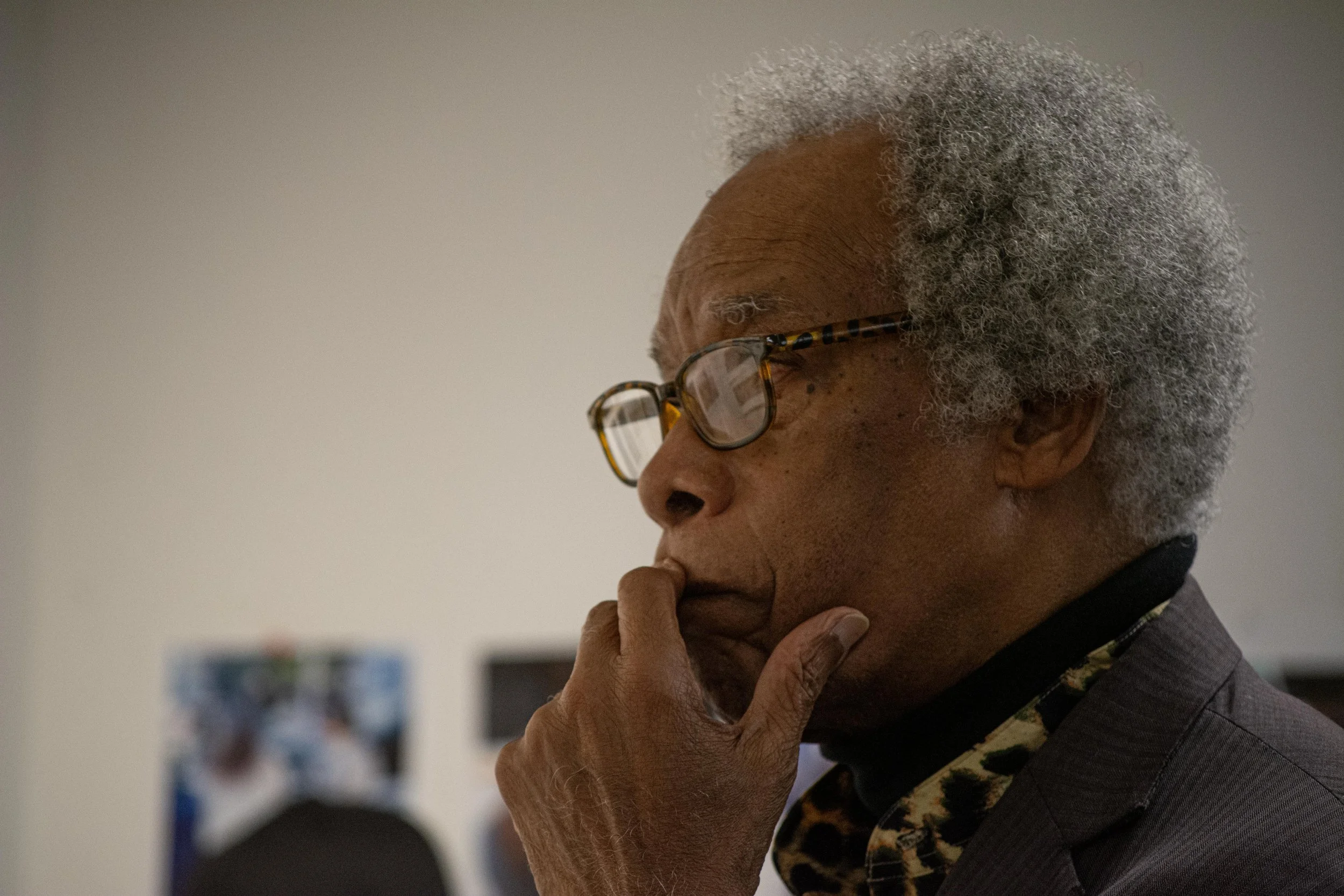 John H. White, a Pulitzer Prize winning photojournalist and longtime professor at Columbia College Chicago, carefully inspects students' photographs during class on Oct. 30, 2025.