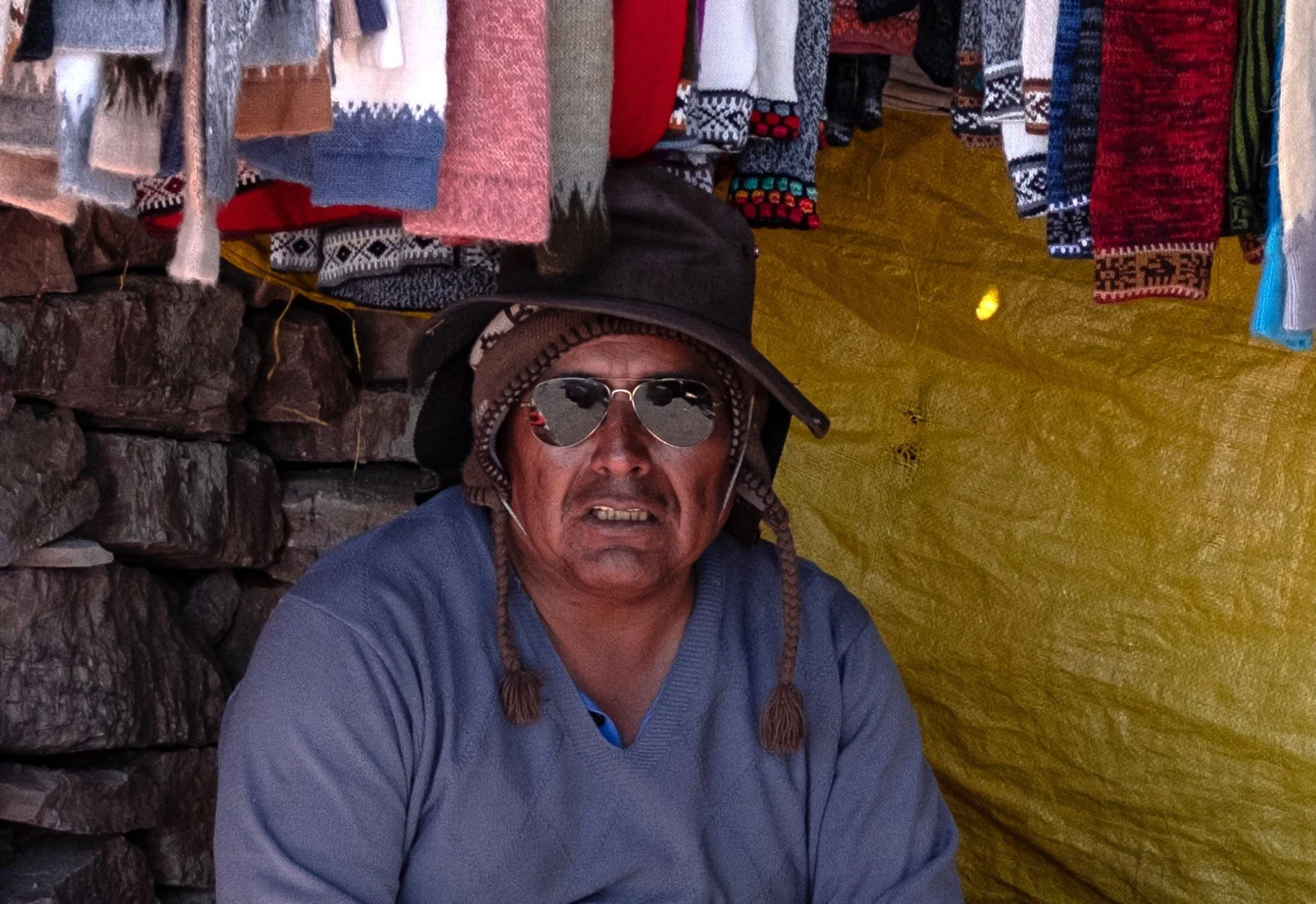 A salesperson in Jujuy, Argentina, escapes the hot sun under a tarp canopy on Jan. 9, 2026.