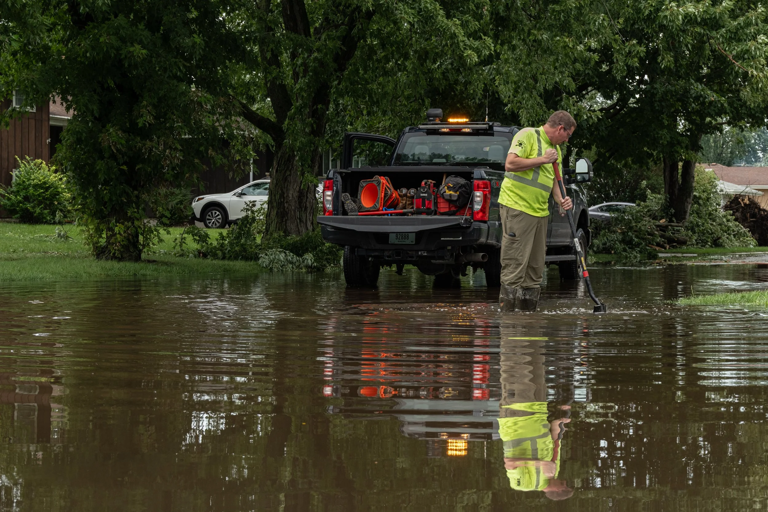 A public works employee for the Town of Munster evaluates street flooding on the corner of Evergreen Lane and Madison Avenue in Munster, Ind., on Wednesday, Aug. 12, 2026.