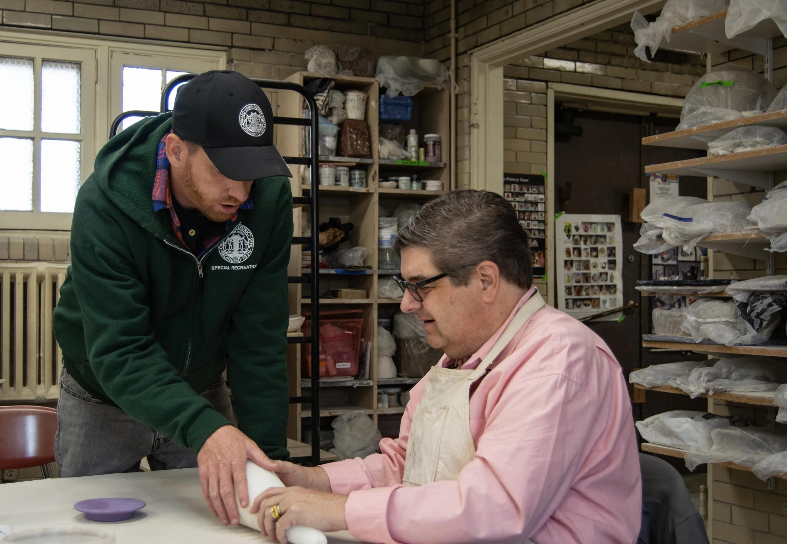 The program and event coordinator for the Chicago Park District specializing in Deaf and hard of hearing communities, Tim Owens, helps Charlie San Fratello, one of the students who is blind, visualize creating a cornucopia on Wednesday, Nov. 4, 2025.