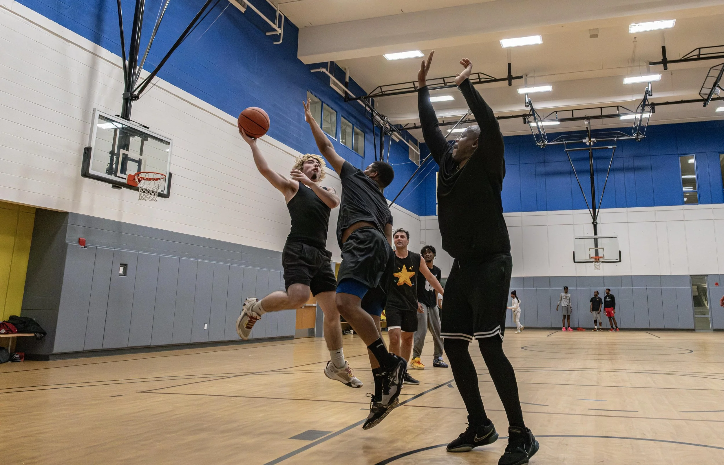 A student jumps up to dunk during a scrimmage basketball game in the East-West University gym on Wednesday, April 29, 2026.