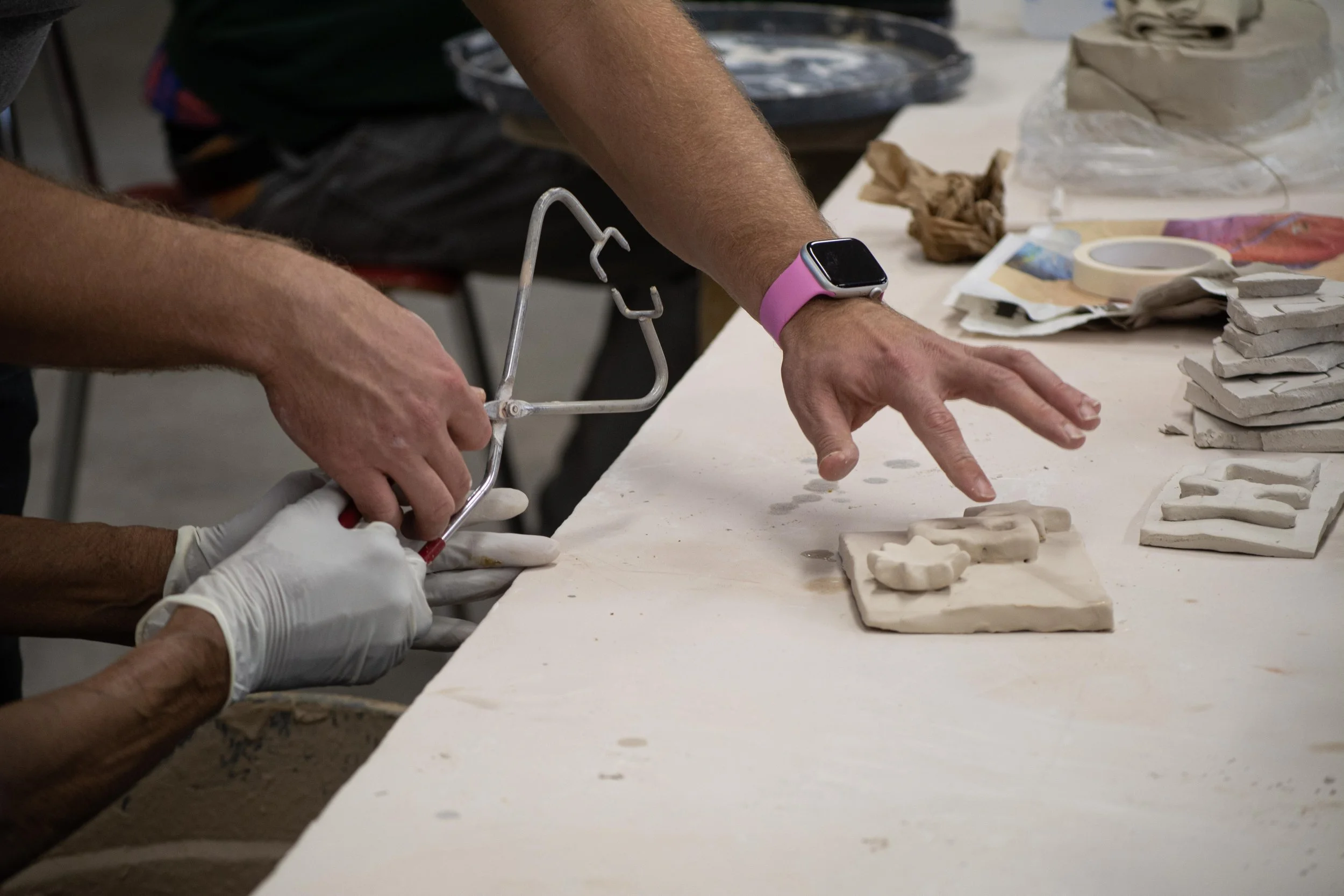 One of the ceramics instructors for the Chicago Park District Athletic Field Ceramics Building, Peter Ronan, shows Valencia Howard how to glaze her pieces before firing on Wednesday, Nov. 4, 2025.