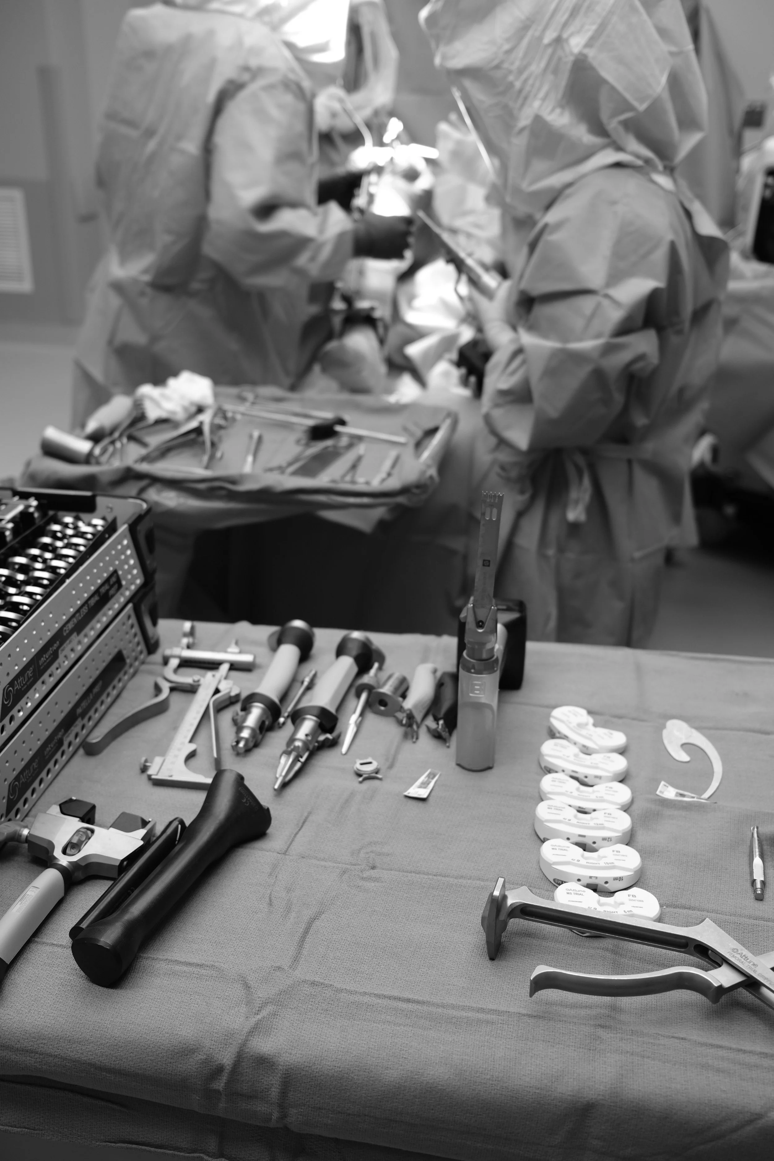 Orthopedic surgical team performing joint replacement surgery in an operating room using specialized orthopedic instruments.