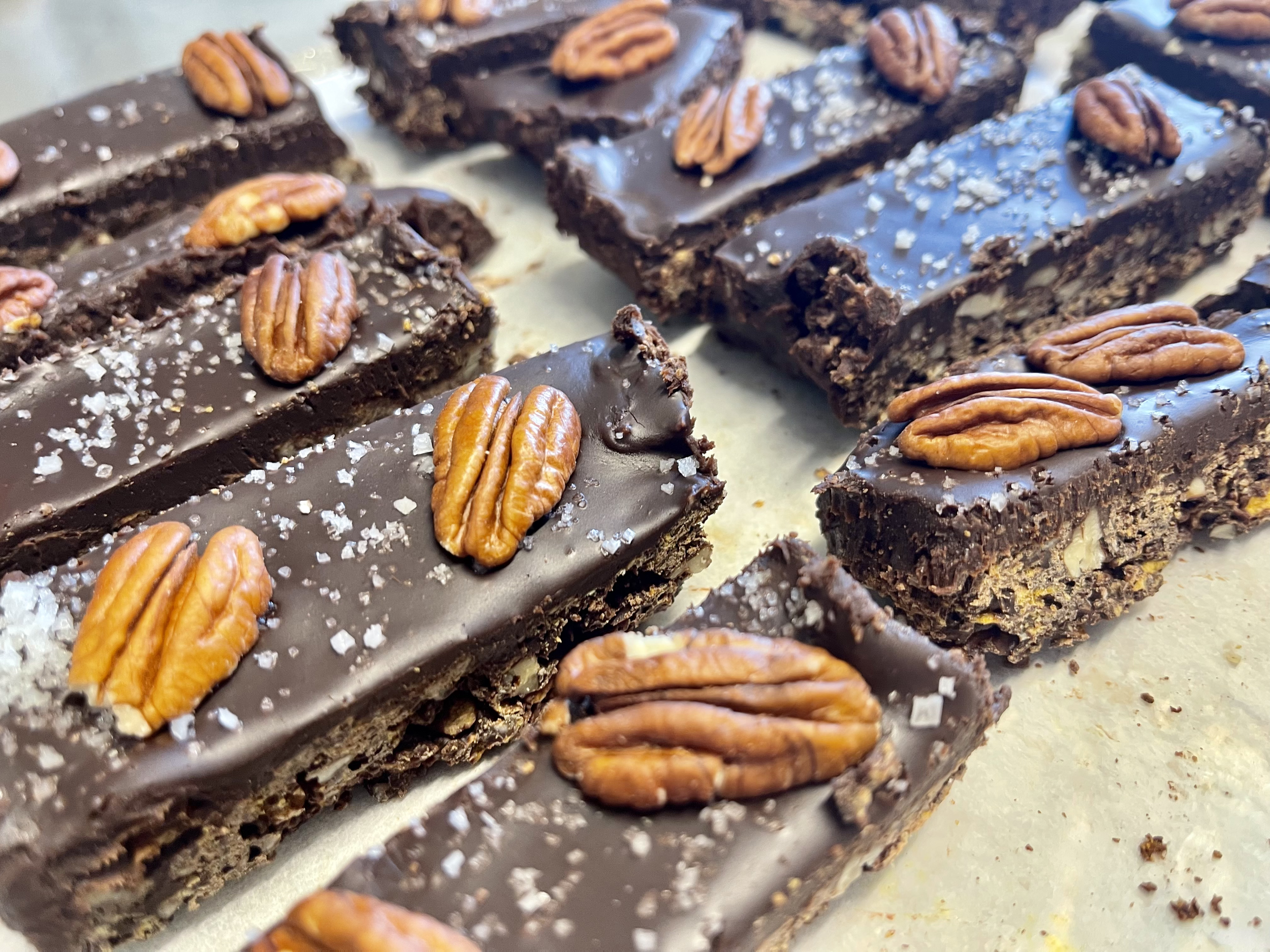 Barres de chocolat avec noix de pécan sur le dessus, saupoudrées de sel de mer.