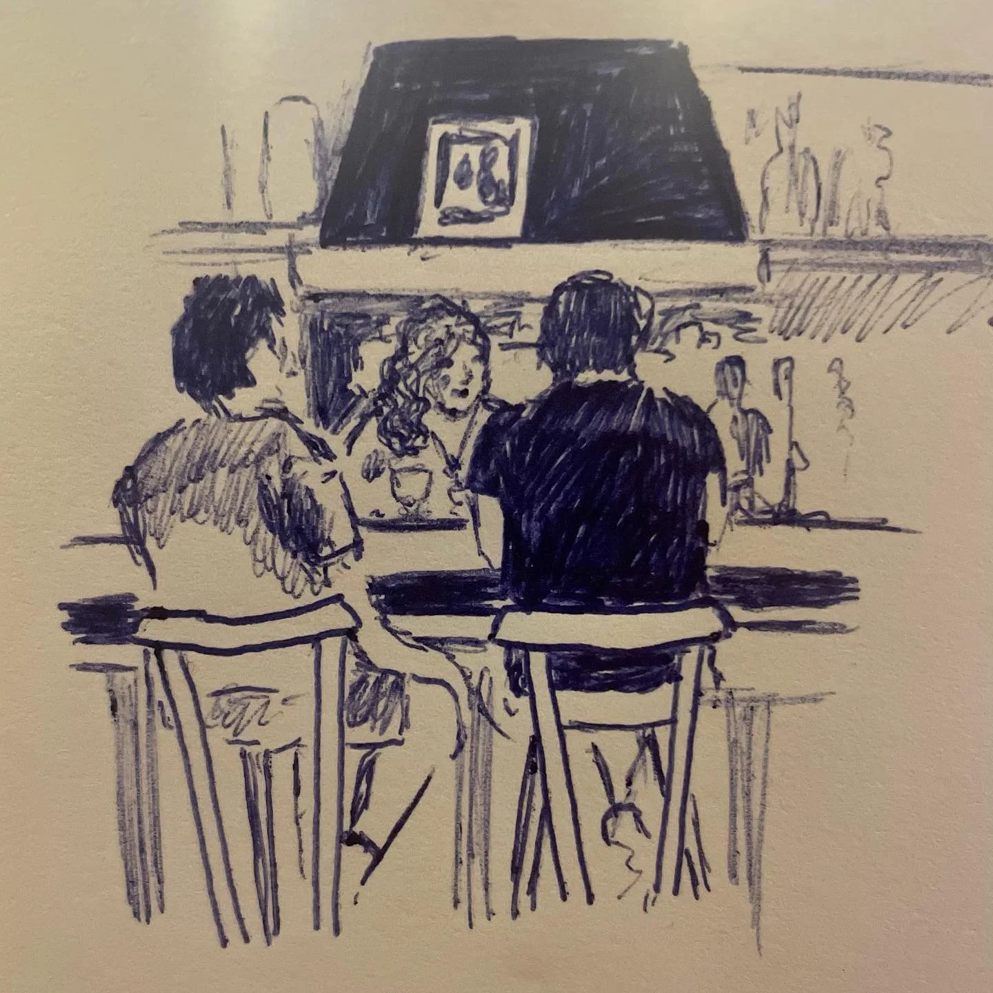 Dessin au stylo montrant trois personnes assises autour d'un comptoir de bar, avec un mur de cheminée en arrière-plan décoré d'une peinture, de vases, et d'objets divers. La scène évoque une conversation détendue dans un environnement intérieur.