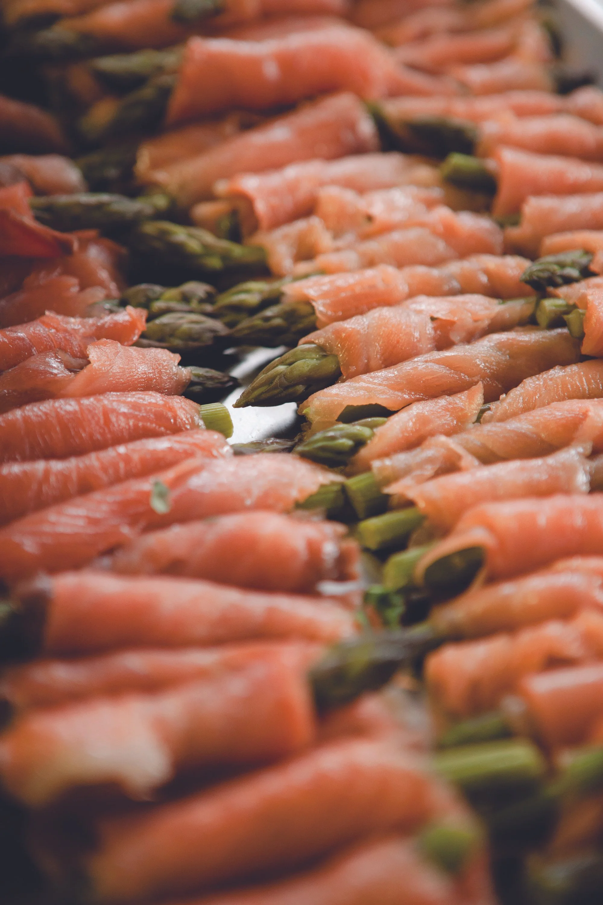 row of asparagus tips wrapped in smoked salmon by spiros caterers