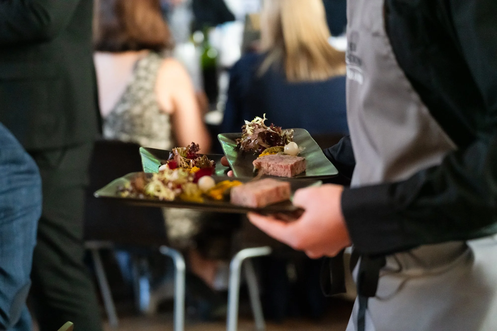 spiros catering team carrying plates of pate out to wedding guests