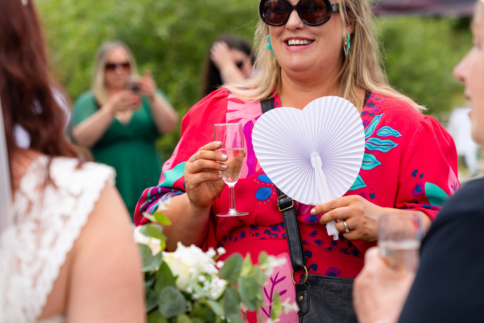 happy wedding guest with heart fan at dyffryn springs