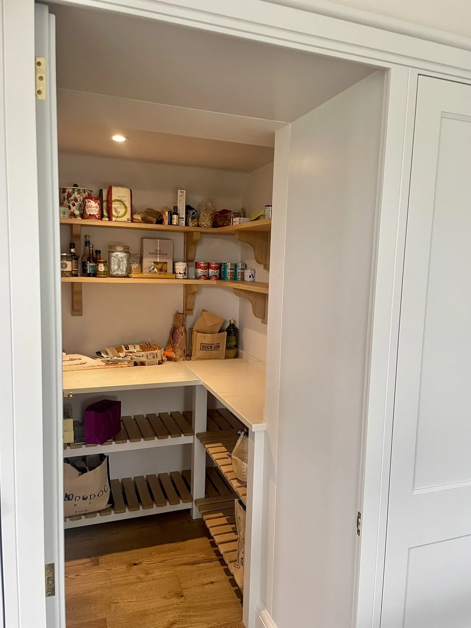 Walk-in pantry with open shelving and integrated storage