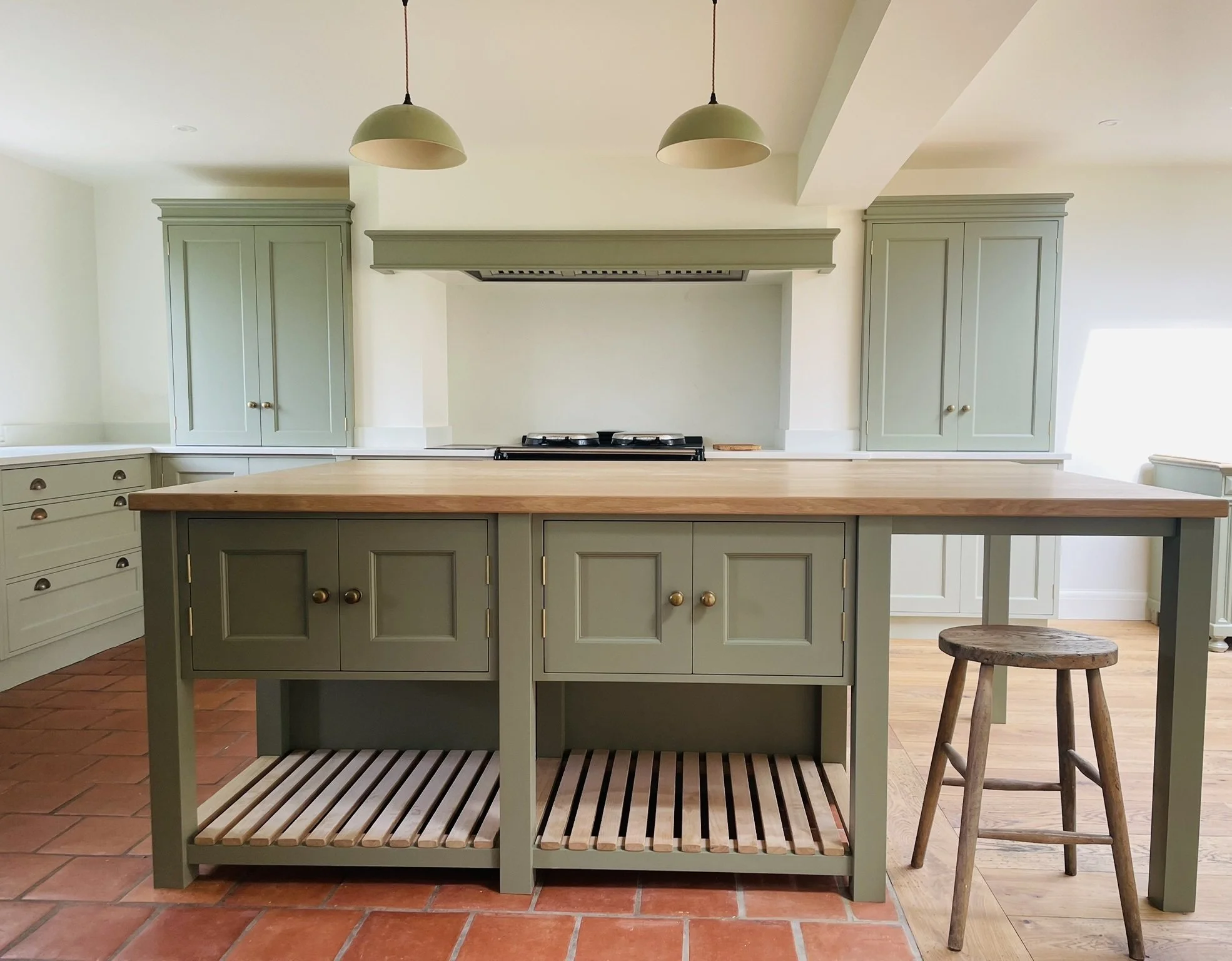 Bespoke painted kitchen with central island designed around an existing chimney breast