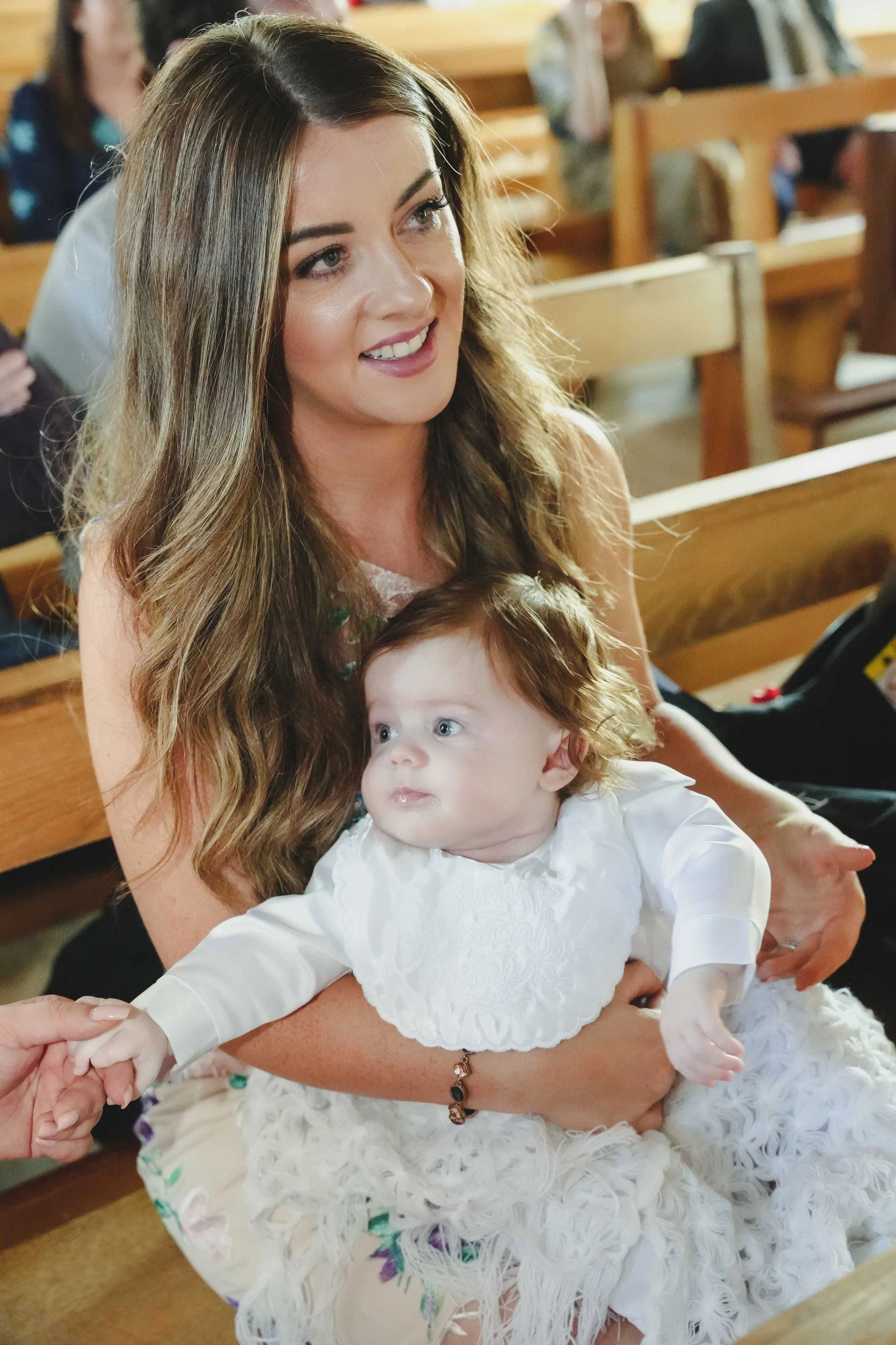 Photograph of a mother holding her child during christening ceremony in Ballyheigue, Co.Kerry.