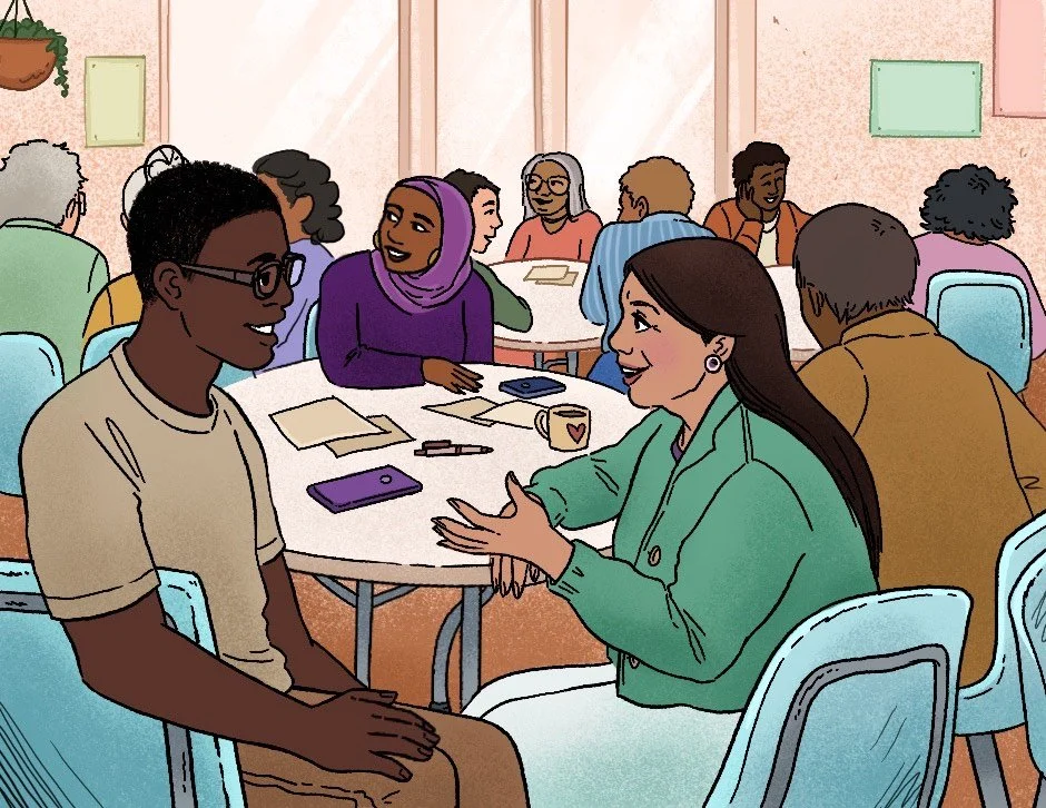 Group of diverse people are engaged in a conversation in a bright room with large windows, sitting around round tables with notebooks, pens, and cups.