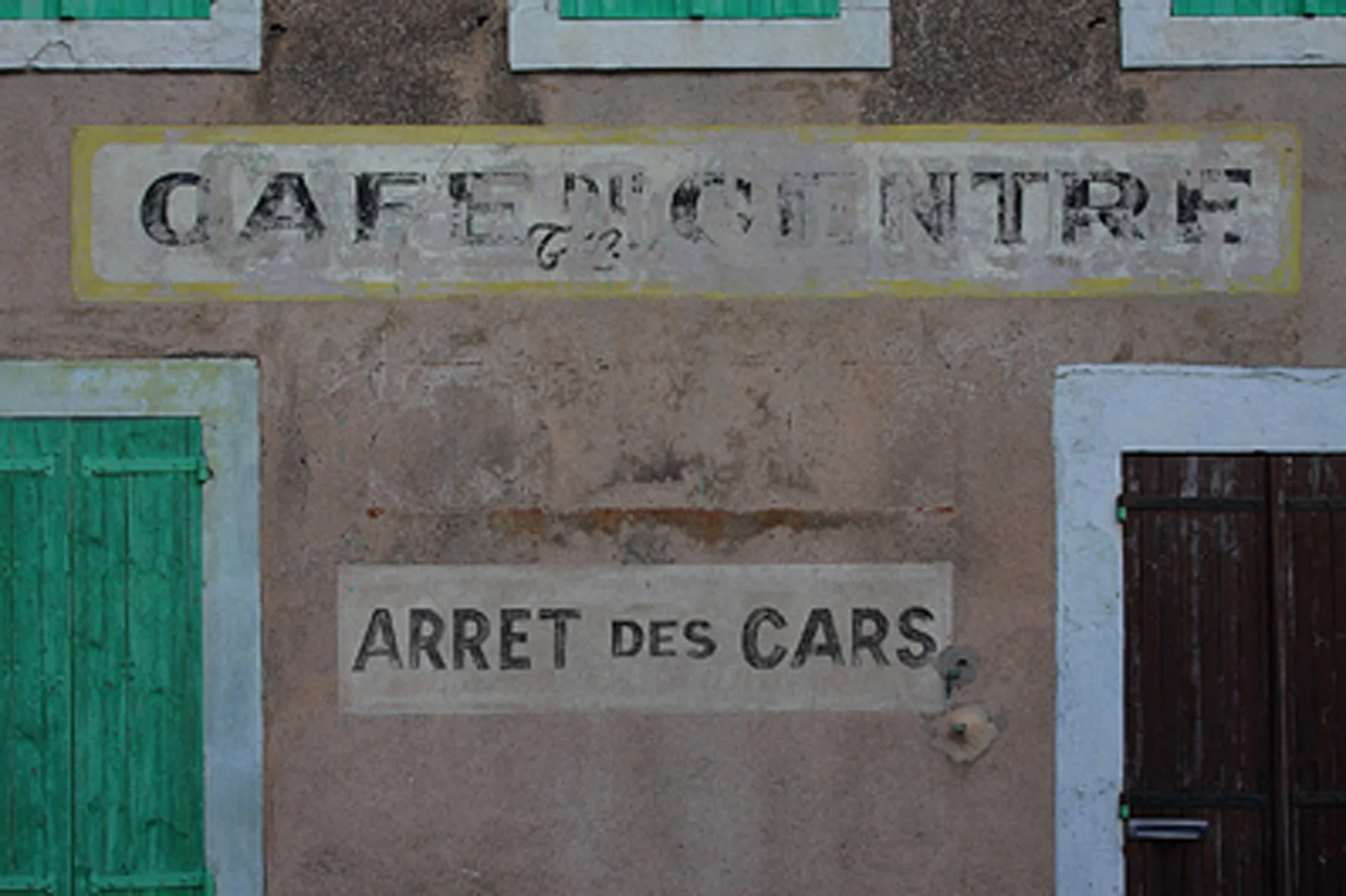 Façade ancienne avec enseignes “Café des Vintre” et “Arrêt des cars”.