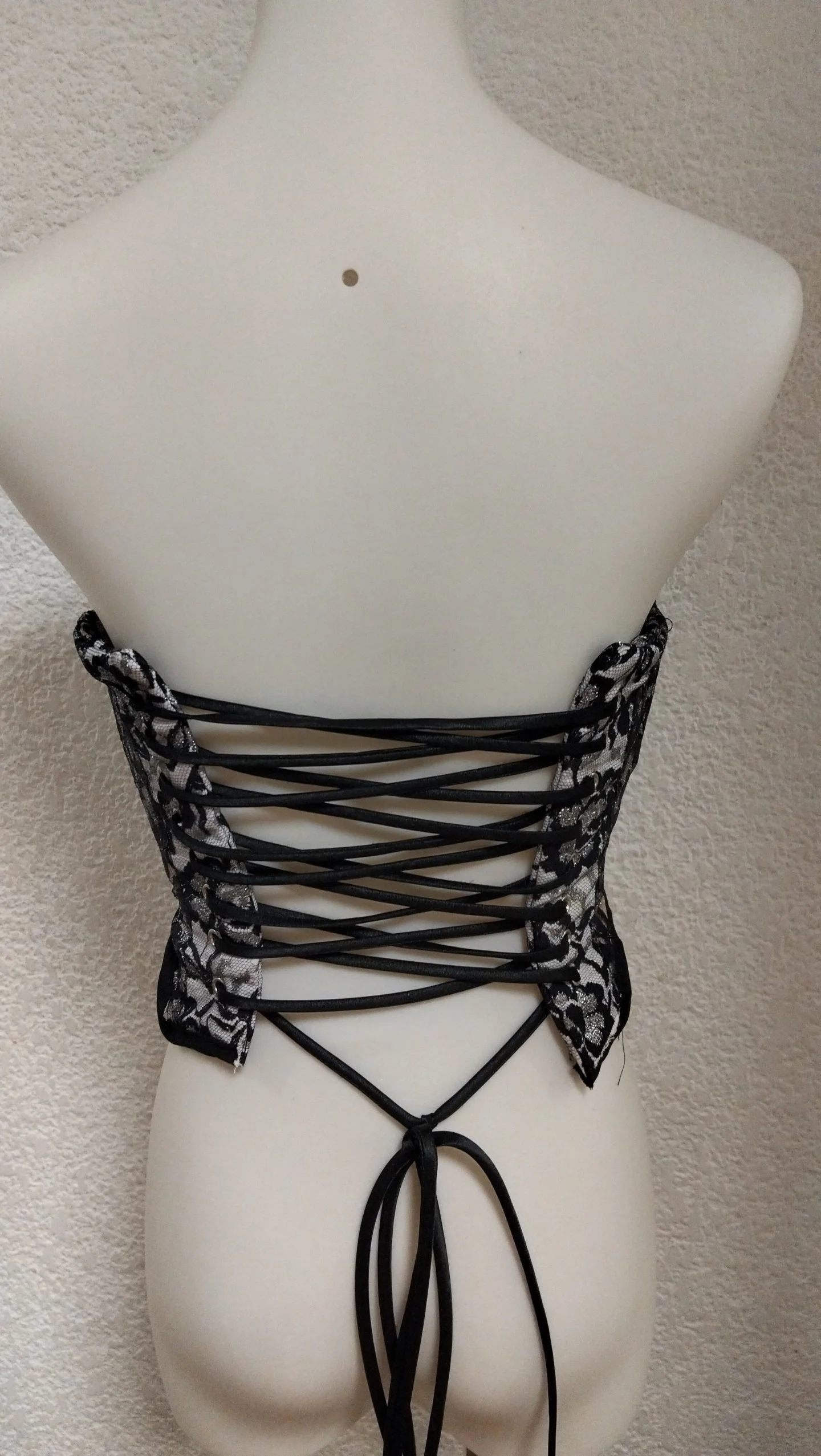 Corsé de encaje negro con detalles plateados.