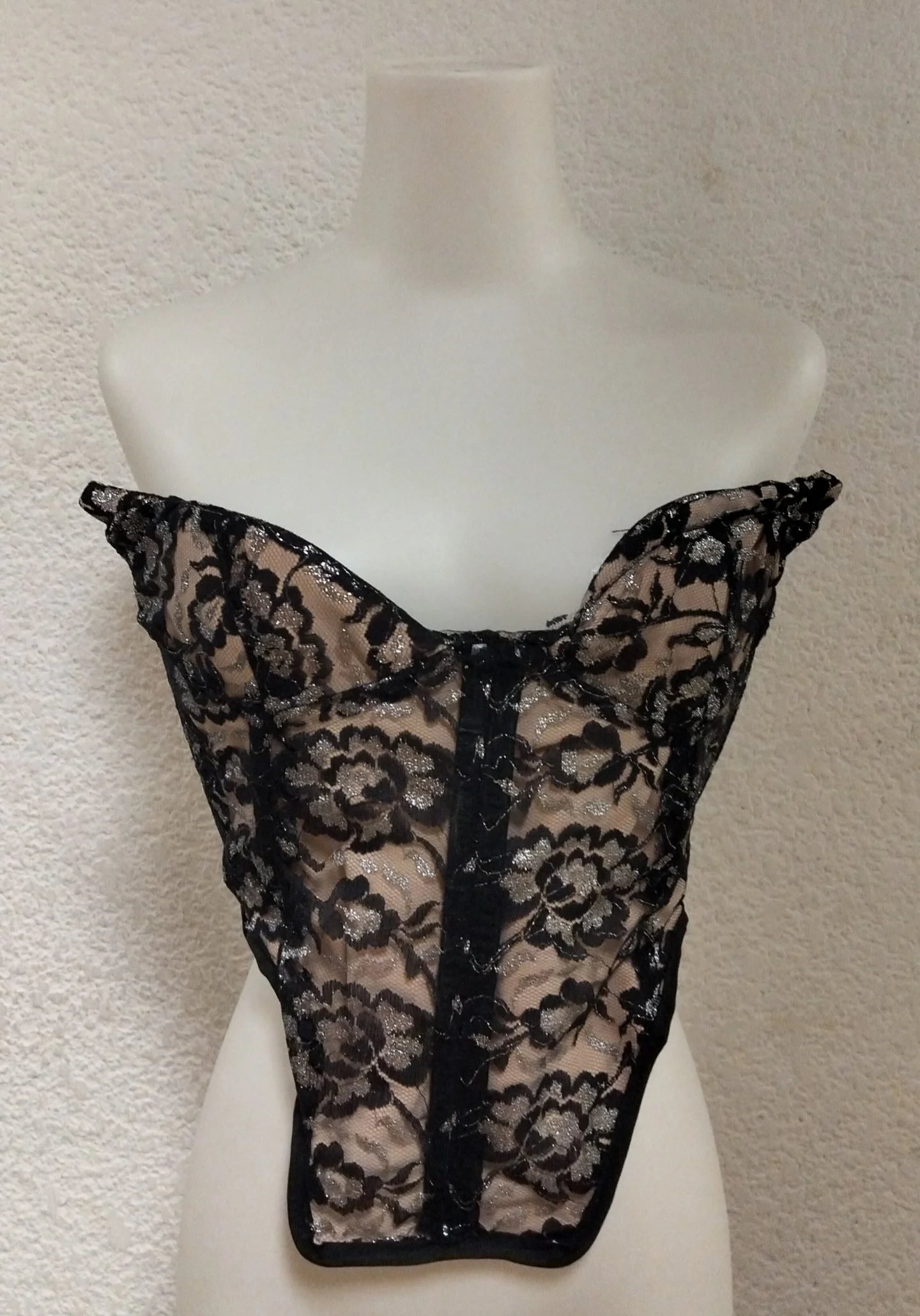 Corsé de encaje negro con detalles plateados.